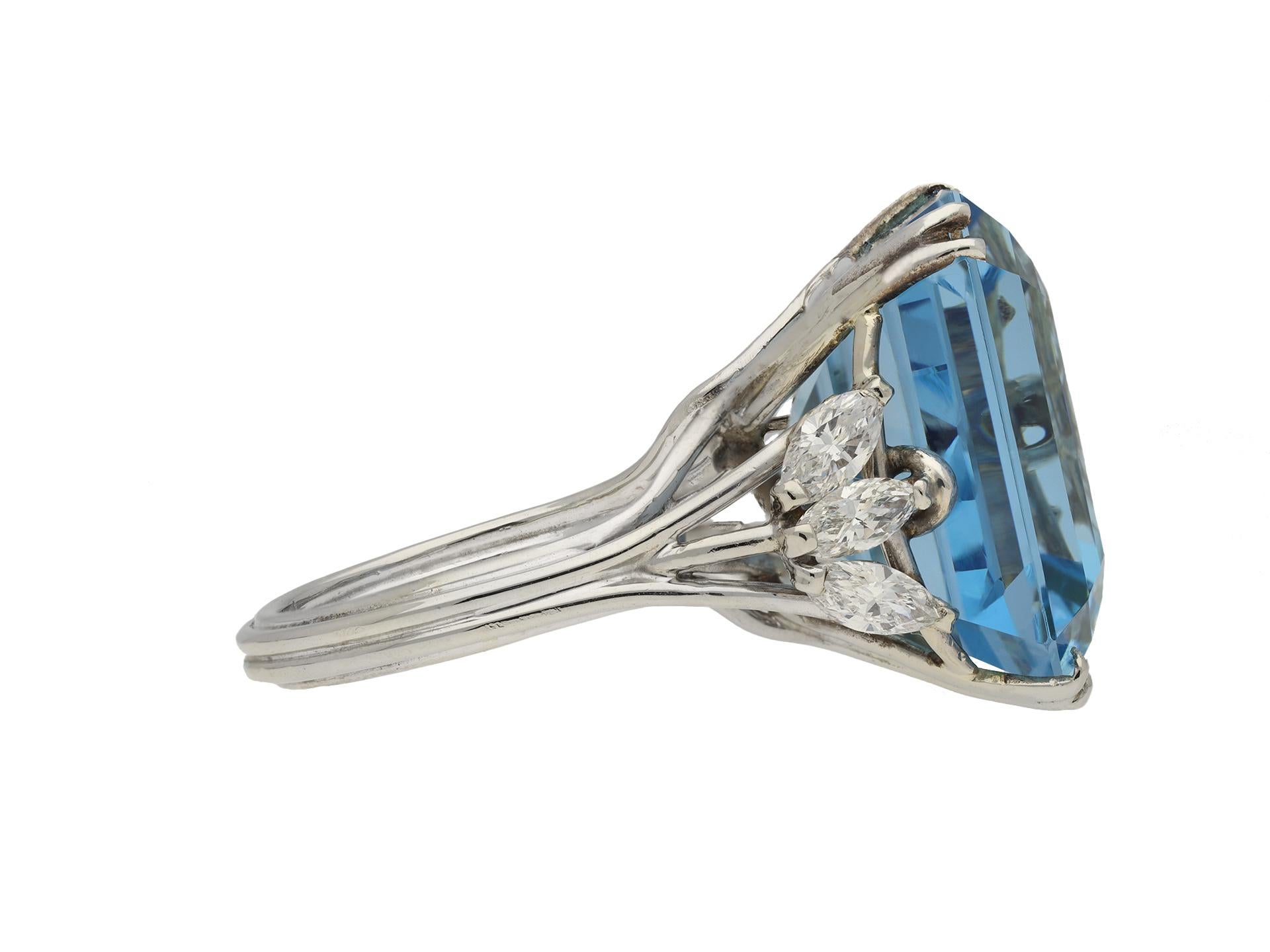 Aquamarine and diamond cocktail ring. Set with an octagonal emerald-cut natural unenhanced aquamarine in an open back claw setting with an approximate weight of 26.80 carats, further set with marquise shape brilliant cut diamonds in open back claw