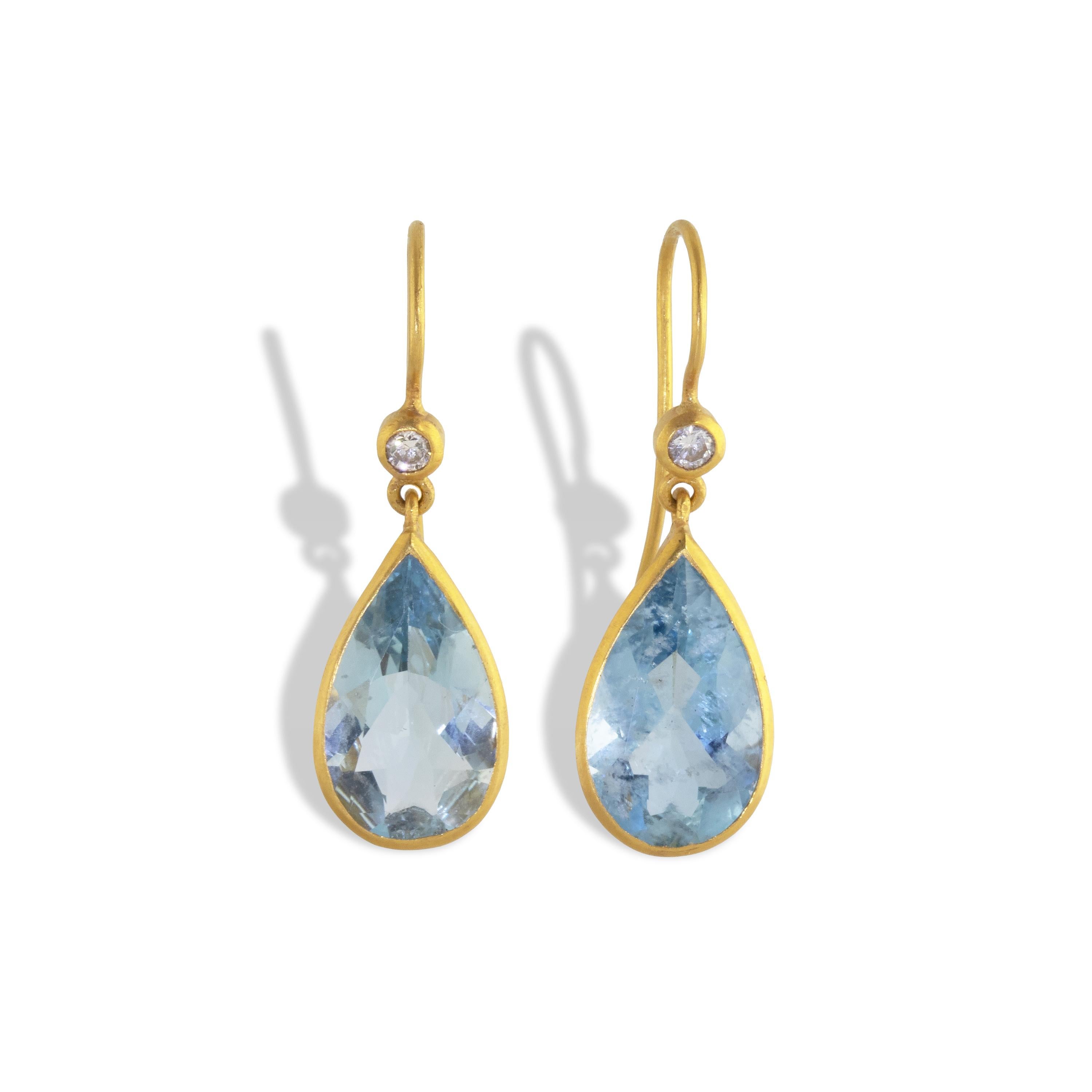 Beautifully unique 5.52 carats of Santa Maria aquamarine drop earrings set in pure brushed 22k yellow gold and accented with .06 carats of round diamonds. The earrings feature large deep blue pear shaped gemstones with a wavy bezel as an ode to the