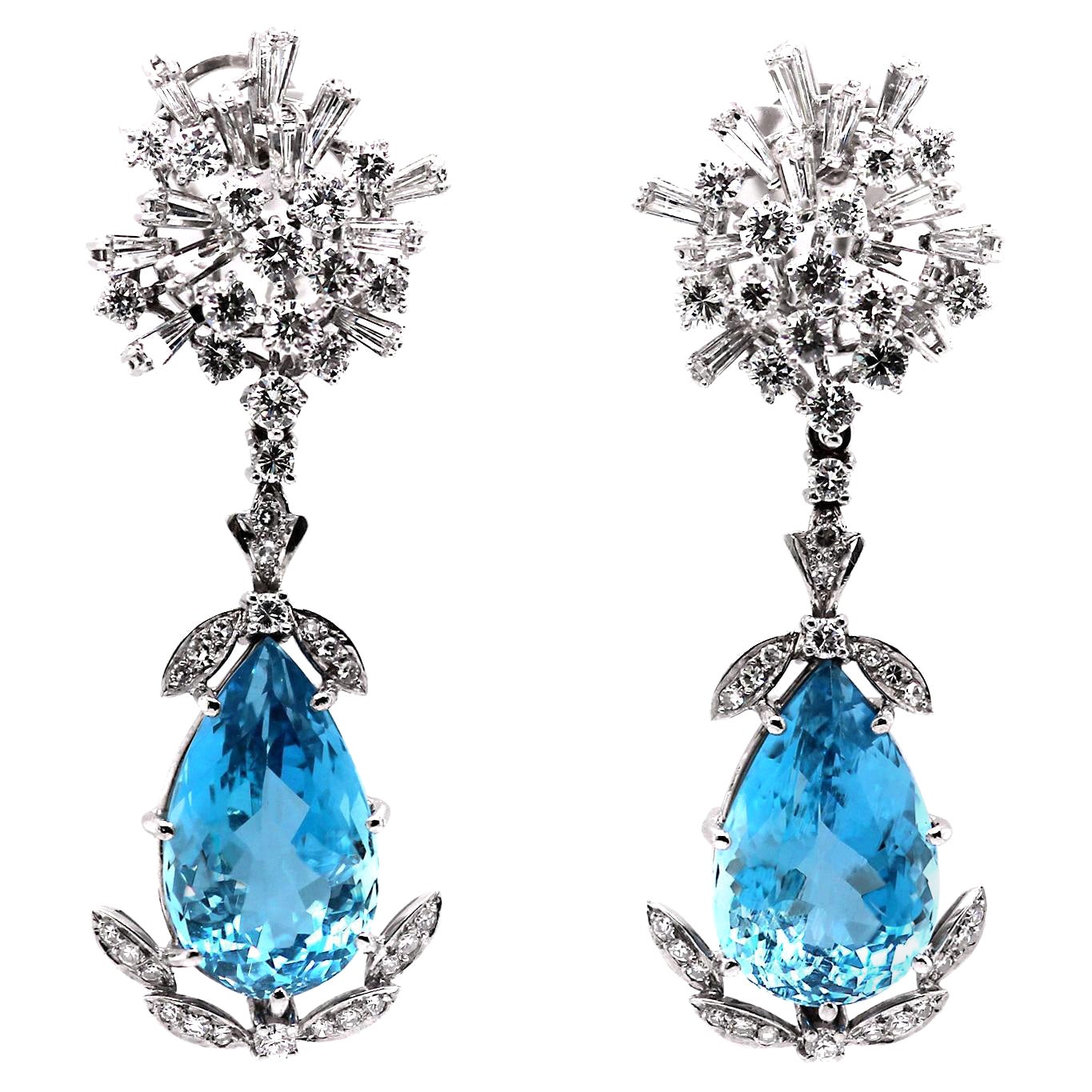 This stunning pair of earrings showcases two exquisite sky blue aquamarine pear drops, elegantly suspended from radiant sunburst clusters of brilliant and tapered baguette diamonds.

The earrings measure 6.7 cm in length and feature a post and