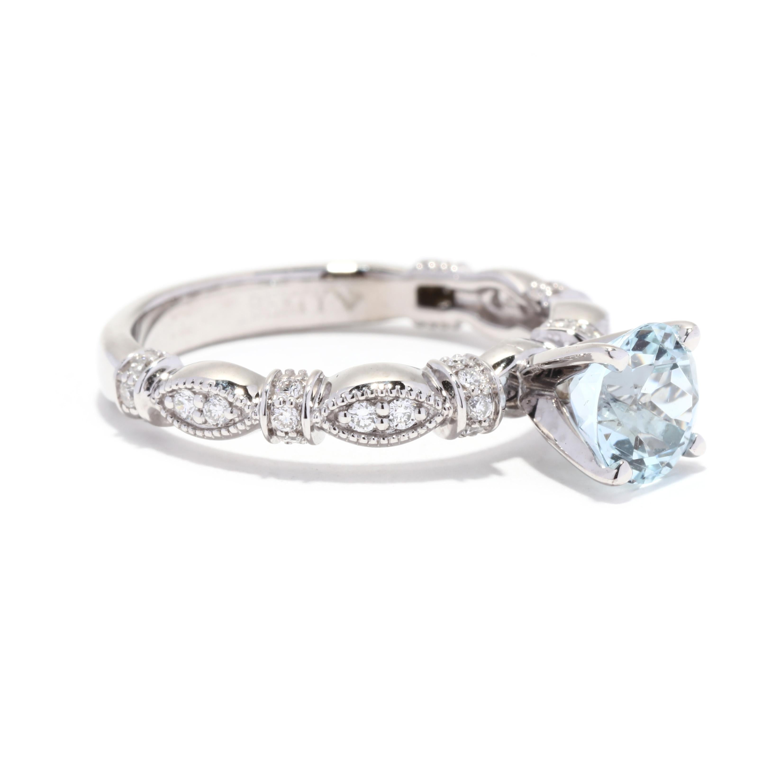 A 14 karat white gold aquamarine and diamond engagement ring. This March birthstone ring features a prong set, round brilliant cut diamond weighing approximately 1 carat set on a marquise set station band set with round brilliant cut diamonds
