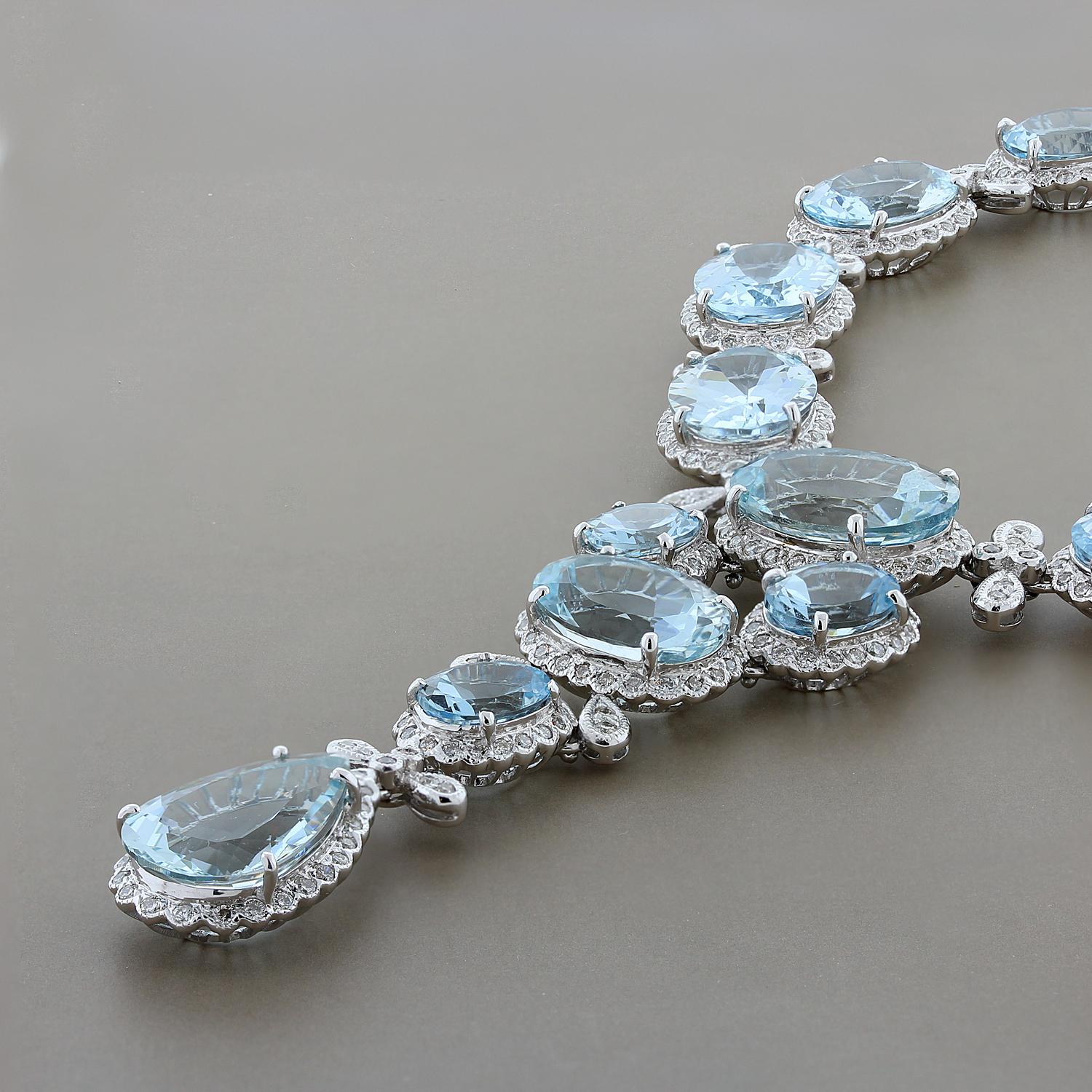 A dazzling necklace featuring 26 graduating oval cut aquamarines with 1 pear cut aquamarine culminating the elegant drop of this exceptional necklace. Each sea blue aquamarine is haloed and accentuated by a total of 5.66 carats of round cut