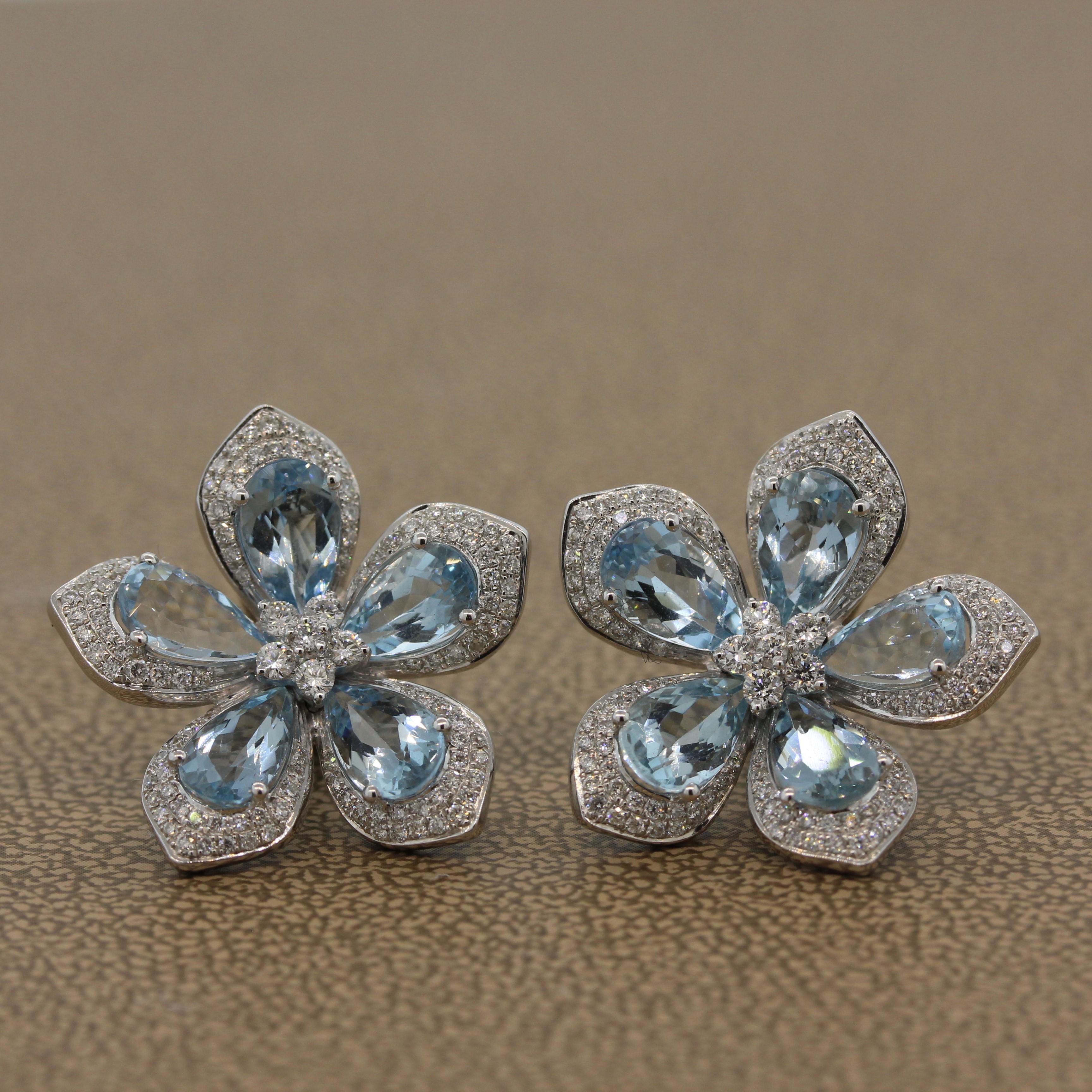 These five petal flower earrings, set in 18K white gold, are comprised of 6.91 carats of pear cut ocean blue aquamarine. With 1.28 carats of diamonds haloing each aquamarine and a flower cluster in the center, these light and feminine earrings will