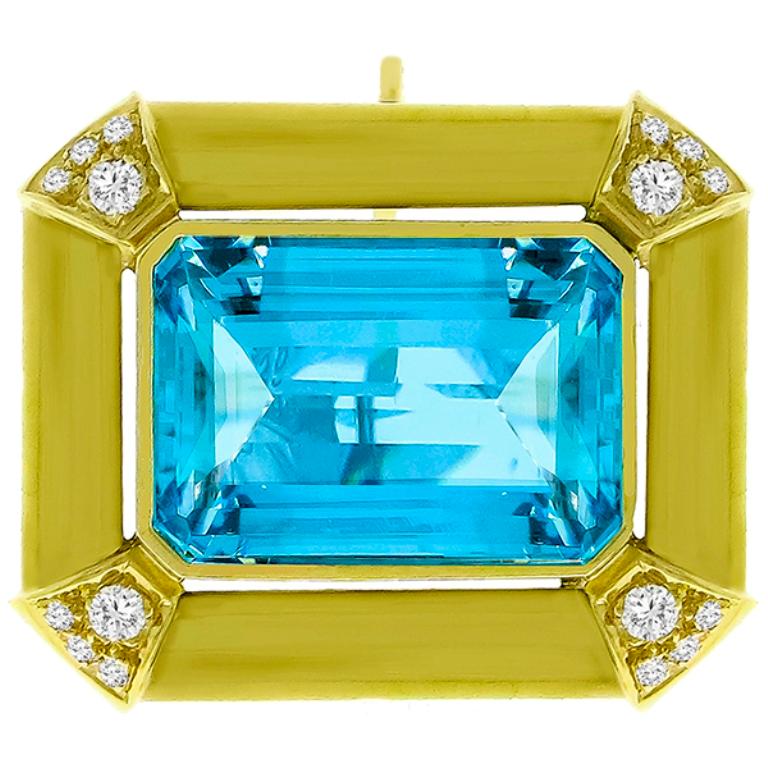 Made of 18k yellow gold, this pin/pendant is set with an emerald cut aquamarine that weighs approximately 25.00ct. The aquamarine is accentuated by approximately 0.50ct round cut diamonds graded F-G color with VS clarity. The pendant measures 27mm