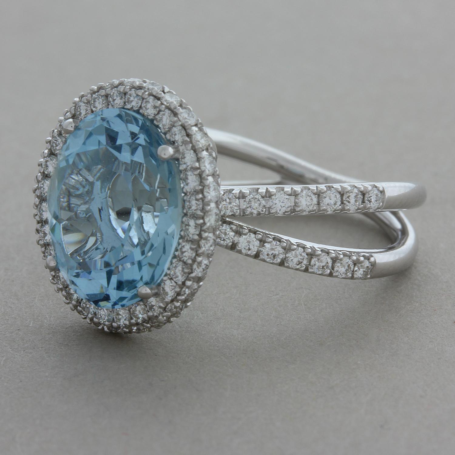 A lovely gem set ring featuring a 4.55 carat oval shaped aquamarine with a lovely blue color that resembles a summer sky. The gemstone is accented by 0.86 carats of round brilliant cut diamonds which halo the gem and run along the shoulders of the