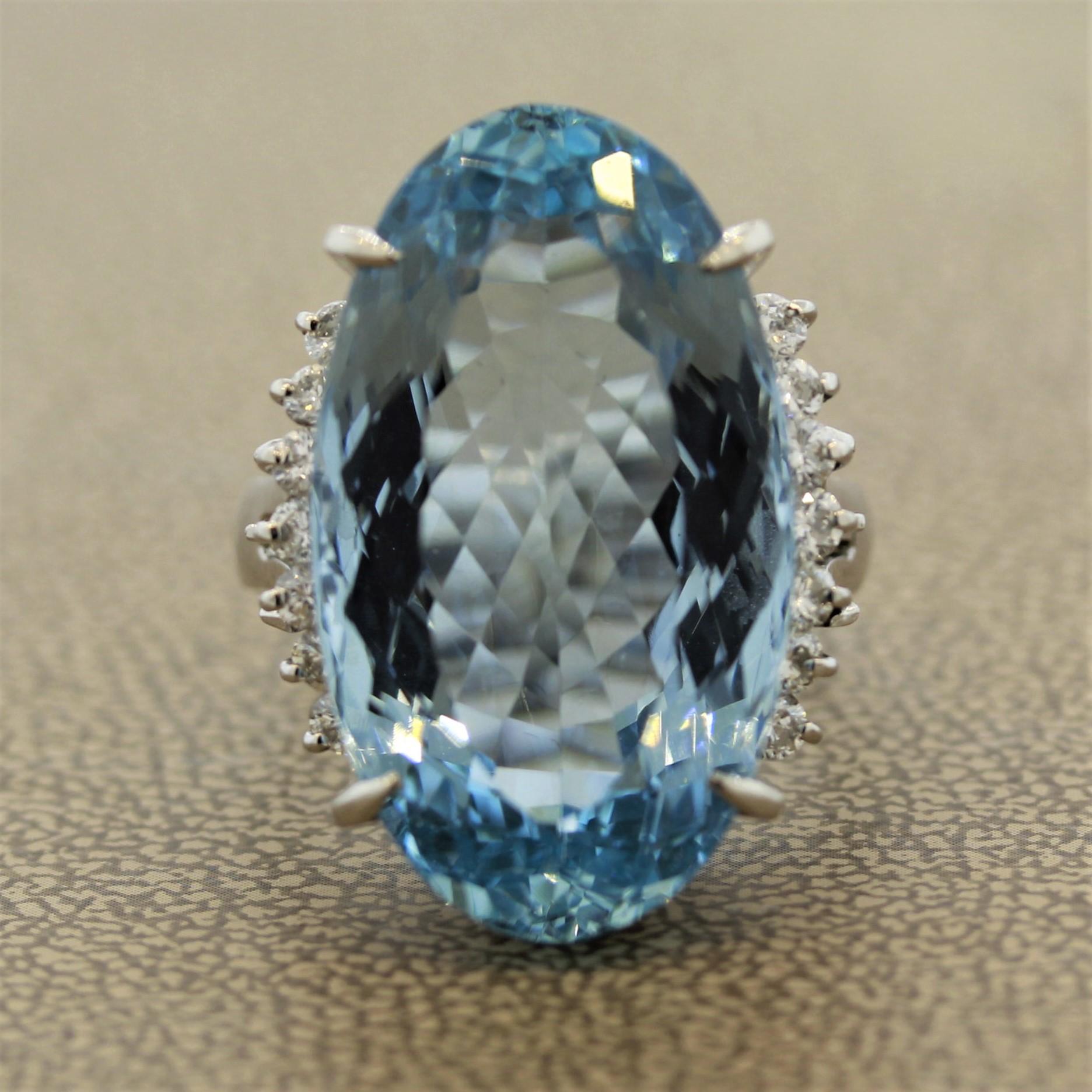 This elegant and brilliant ring will surely be noticed even from far away as it boasts an immense 22.70 carat aquamarine as the center stone. The aquamarine has a superb shape along with a sweet ocean blue color, a truly fine stone. Accenting the