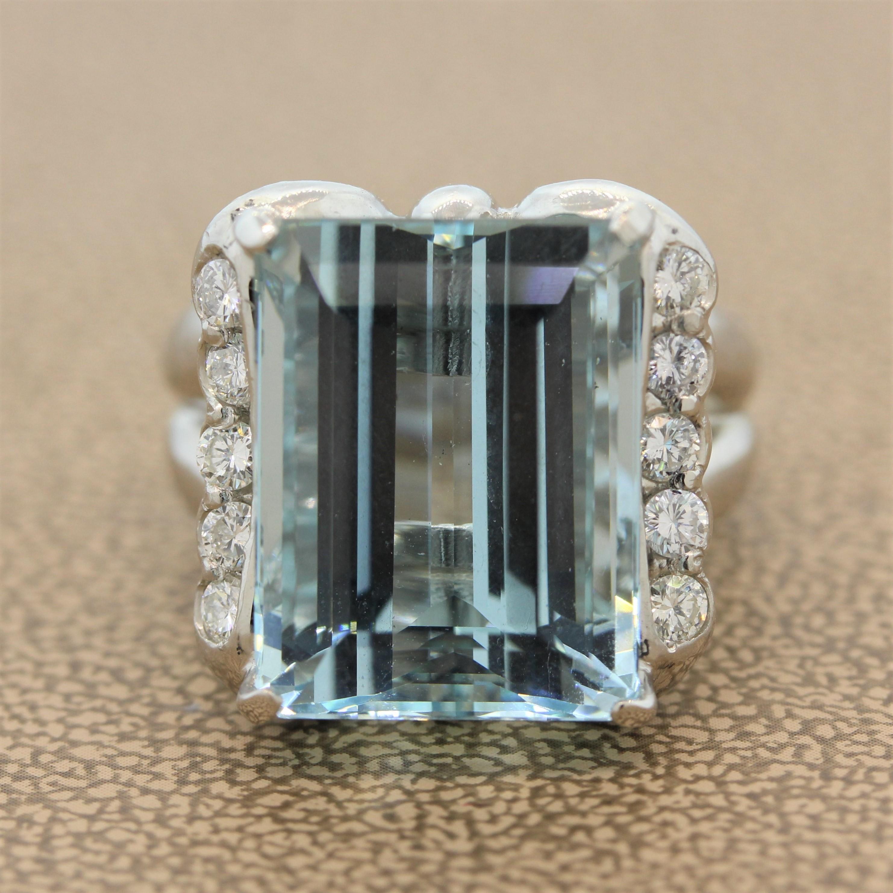 A gorgeous ring featuring a 14.69 carat aquamarine in a luxurious platinum setting. The emerald cut aquamarine has a soft sea blue hue and is accented by 0.50 carats of round brilliant cut diamonds set in a linear fashion to its right and left side.