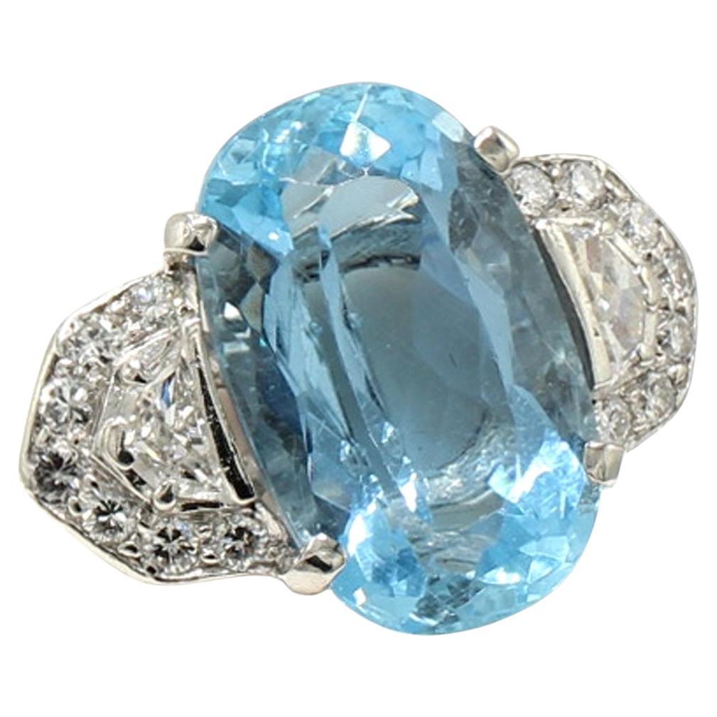 Questo anello in platino degli anni '50, dal design splendido e magistralmente realizzato a mano, presenta una splendida acquamarina dal taglio ovale del peso di 9,88 carati. La gemma centrale è impreziosita da due diamanti bianchi e scintillanti a