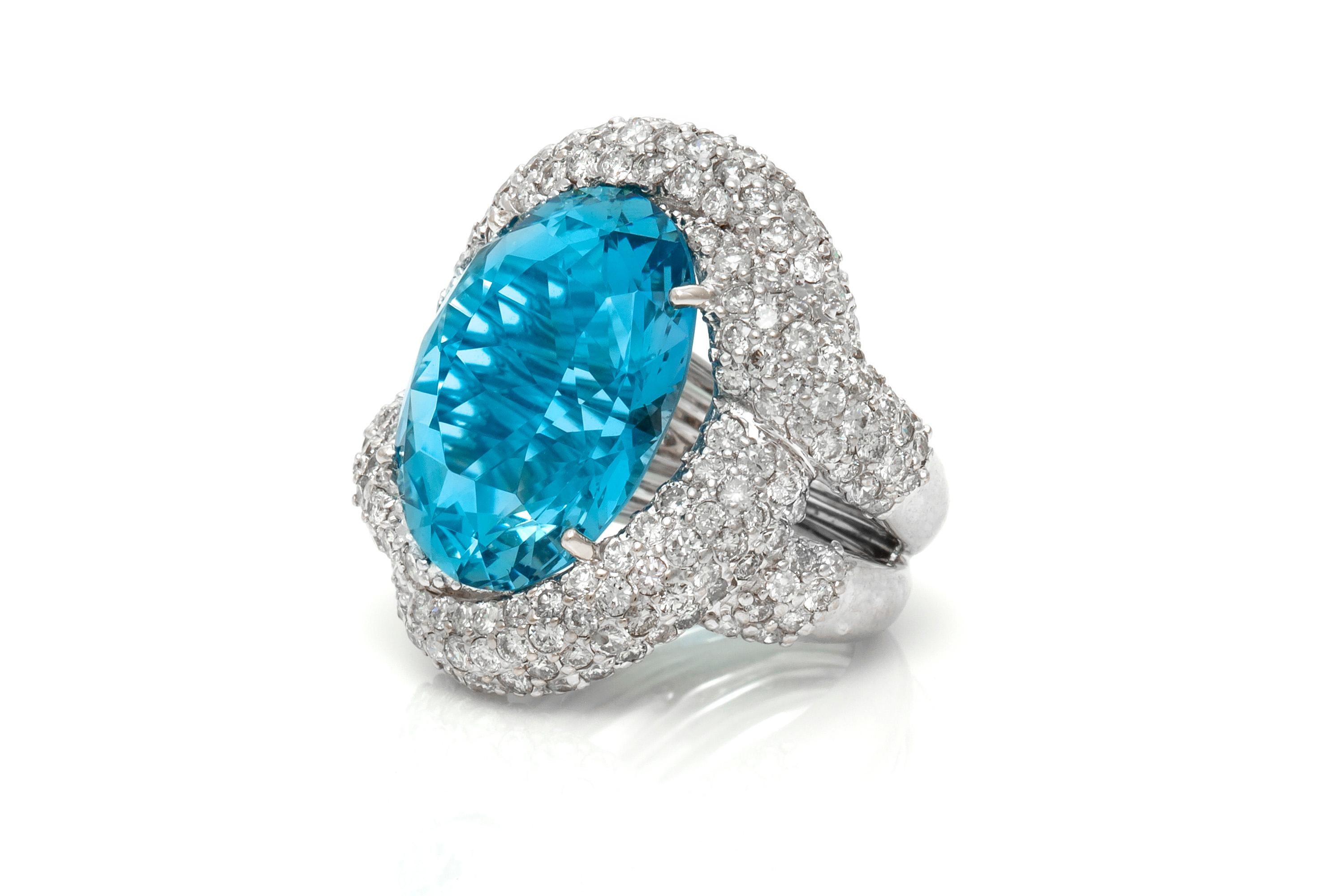 Cocktail ring, finely crafted in platinum with oval aquamarine center stone weighing a total of 17.40 carats and diamonds around weighing approximately a total of 4.50 carats.
