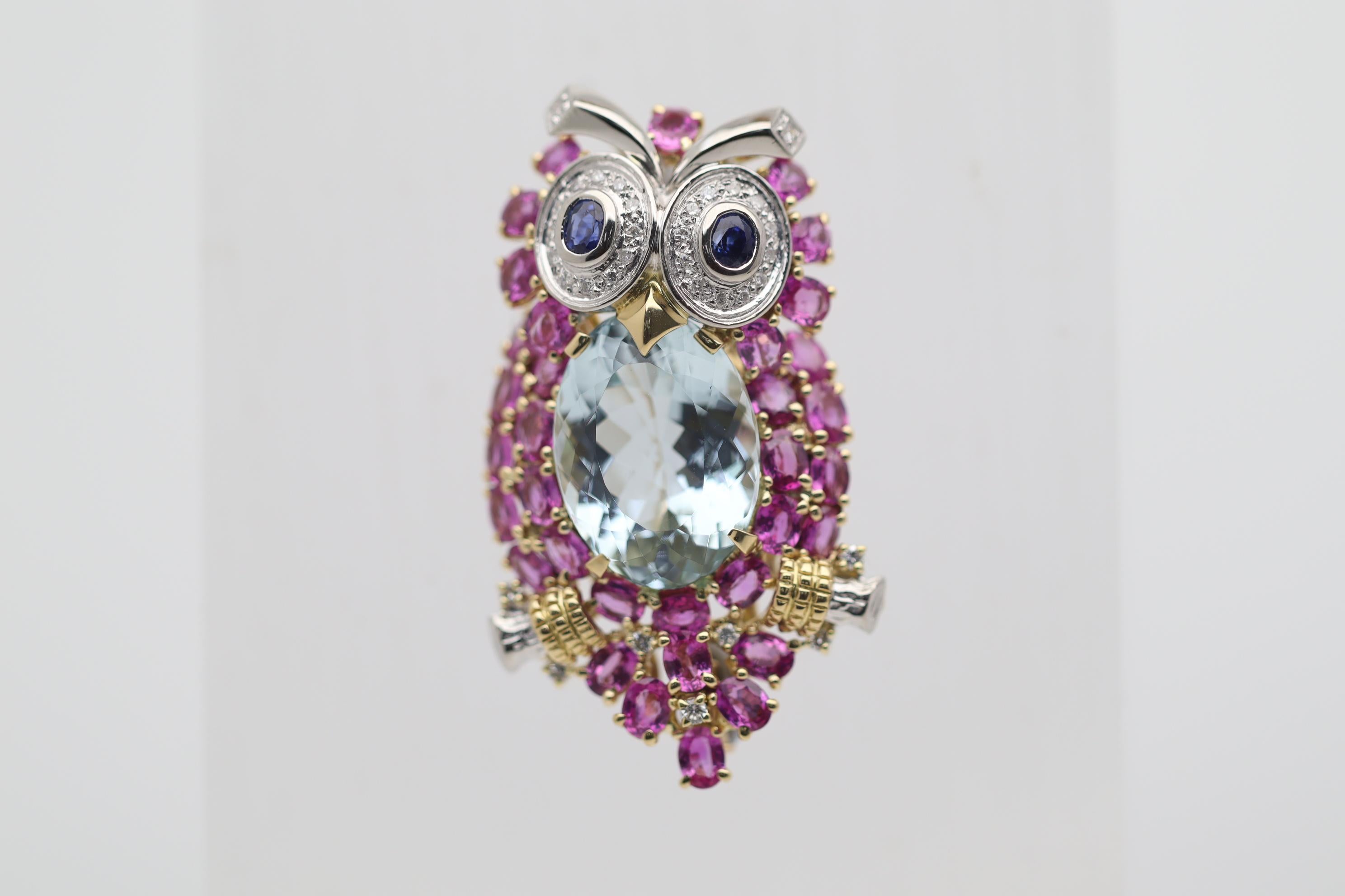 A stunningly adorable piece of fine jewelry! This friendly owl features a 12.64 carat aquamarine with a clean sea-blue color. Contrasting with the blue aquamarine are 6.23 carats of vivid pink sapphires set around the body as the owl’s feathers. Two