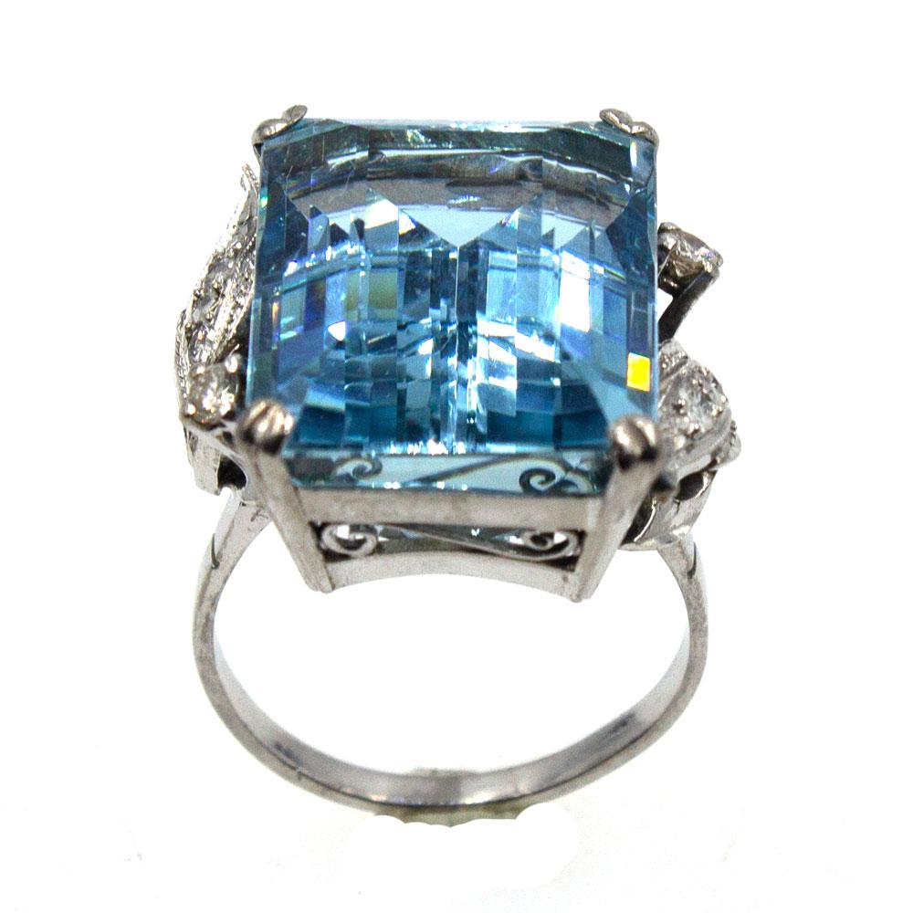 This fabulous cocktail ring features a 26.14 carat beautiful blue aquamarine gemstone set in 14 karat white gold. The ring also features .25 carat total weight of round brilliant cut diamonds. The aquamarine measures 19.5 x 15mm and the ring is