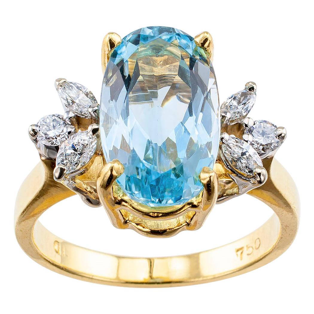 Aquamarine and diamond yellow gold ring circa 1970. Centering upon an oval aquamarine weighing approximately 2.75 carats and displaying a beautiful blue color, flanked by diamond trios, comprising marquise and round brilliant-cut diamonds totaling