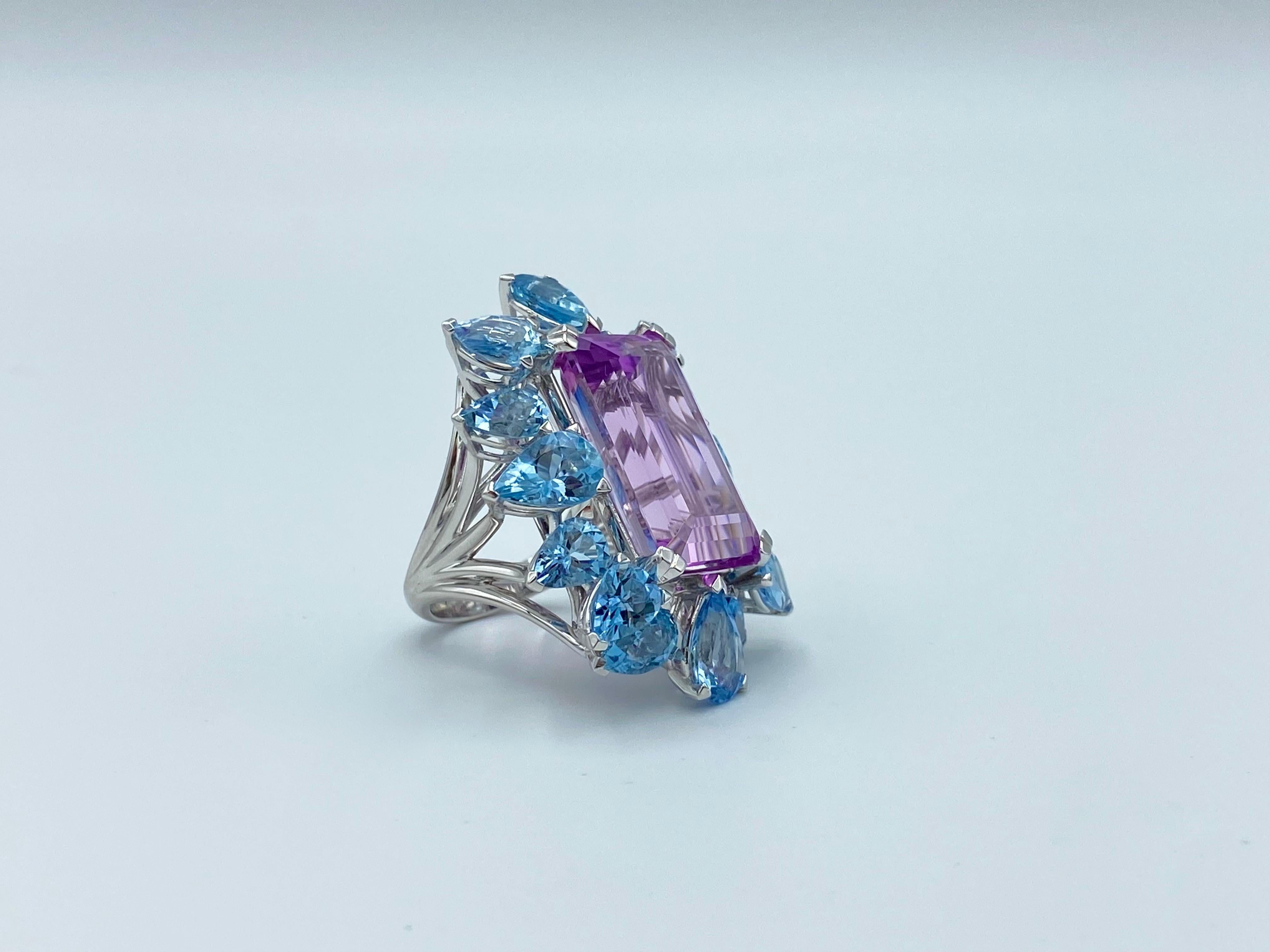 It is a very suggestive, fascinating and lively ring for its size and for its bright colors given by an emerald cut kunzite 20.5 x 13 mm and by the 16 drops of pear cut aquamarine.
Kunzite is 23.79 ct.
The aquamarines are in total 10.40 ct.
The ring