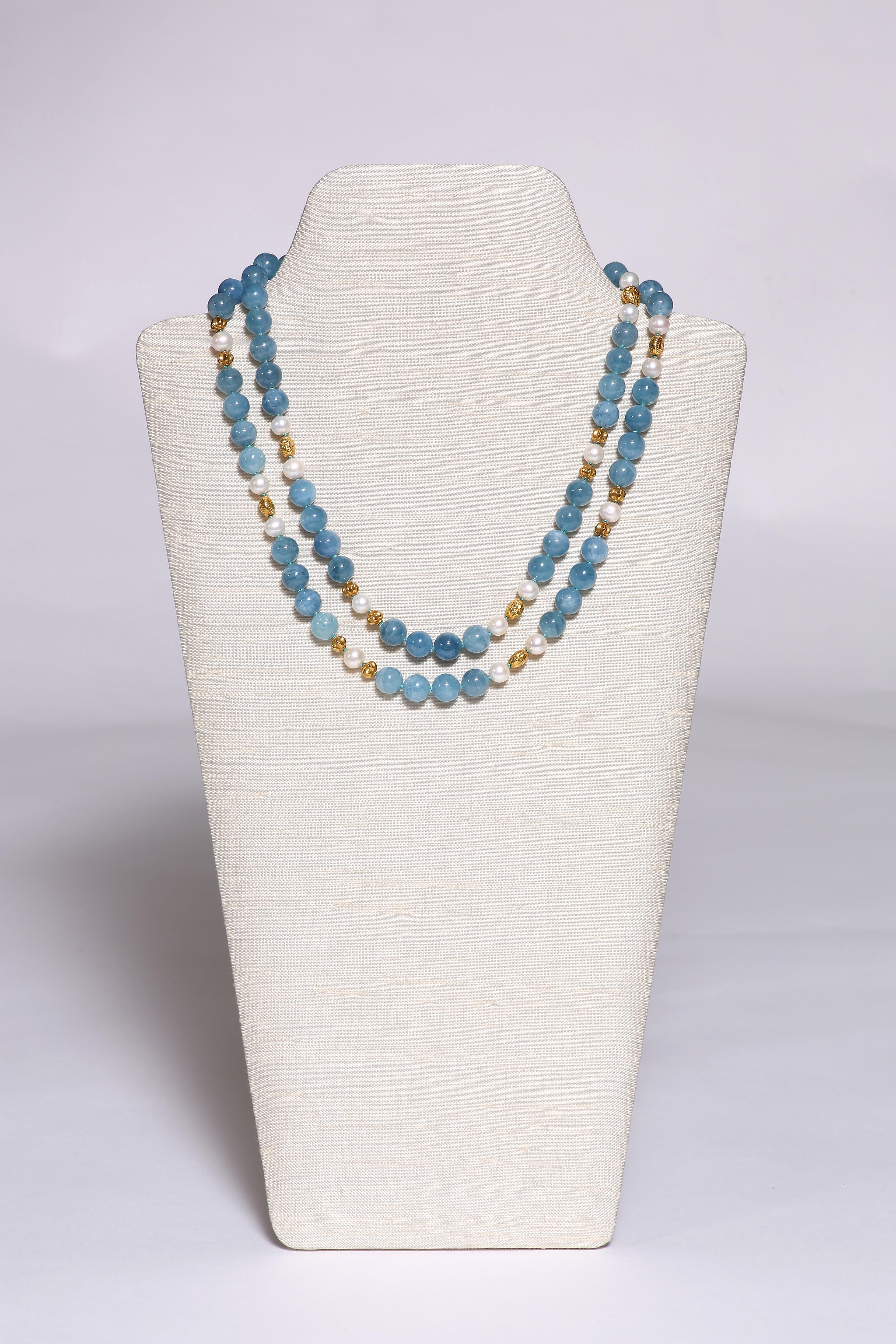 The long necklace of noble blue aquamarine, spaced by freshwater pearls and 18k gold beads ribbed or in the shape of seashells, is 41 3/4