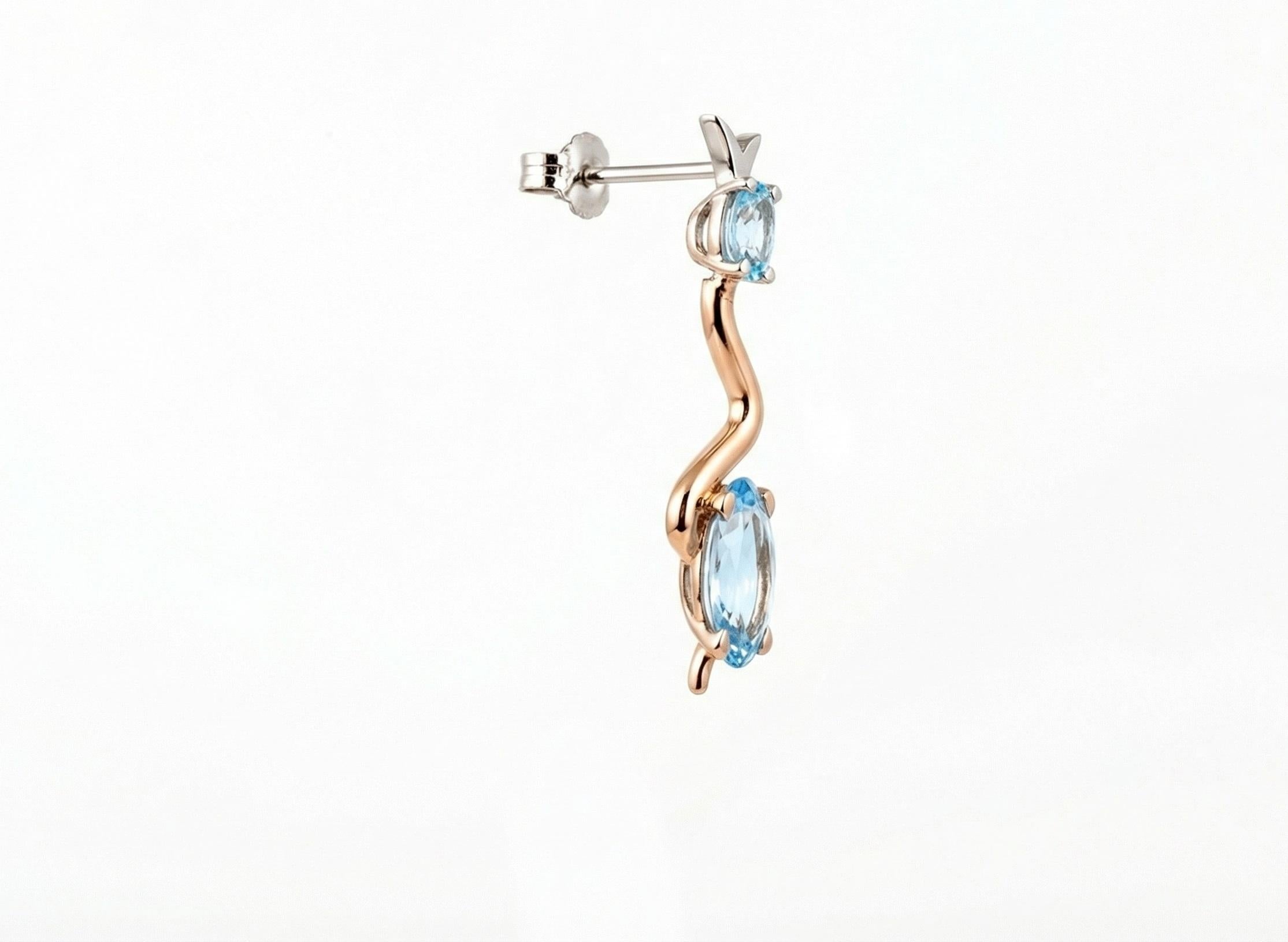 Ces boucles d'oreilles exclusives et extravagantes séduisent par leur design unique et leurs magnifiques aigues-marines taillées en ovale et en marquise, retenues par un serpent en or rose et en or blanc 18 carats. 

La flexibilité des boucles