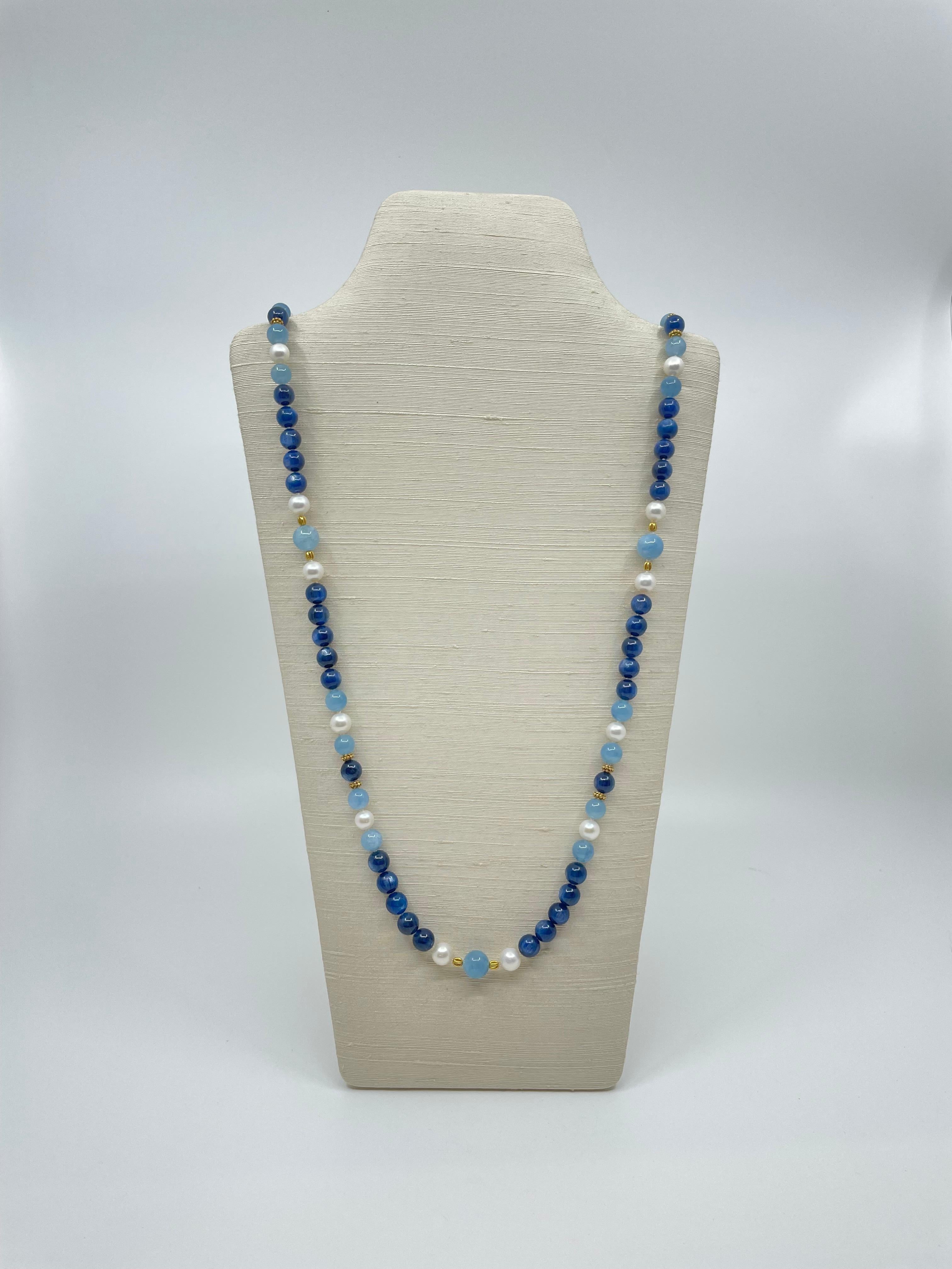 A hand-made long necklace of wonderful dark blue kyanite beads, round aquamarine beads, freshwater pearls, spaced by 18k gold beads, closes with an 18k gold toggle clasp. 
The lovely piece could be worn as a long necklace or double it to be a
