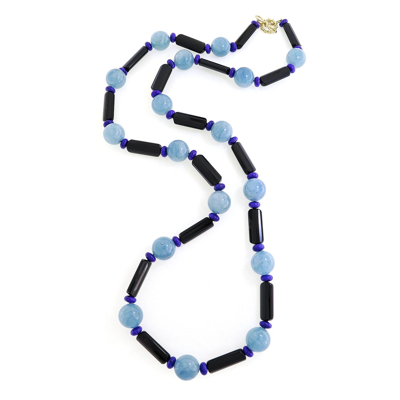 Three gems represent a spectrum of tints for this necklace. Slim black onyx cylinders are combined with lapis lazuli rondelles. In between these are aquamarine orbs. The total weights of the gems are 17 carats of aquamarine, 18 carats of black onyx