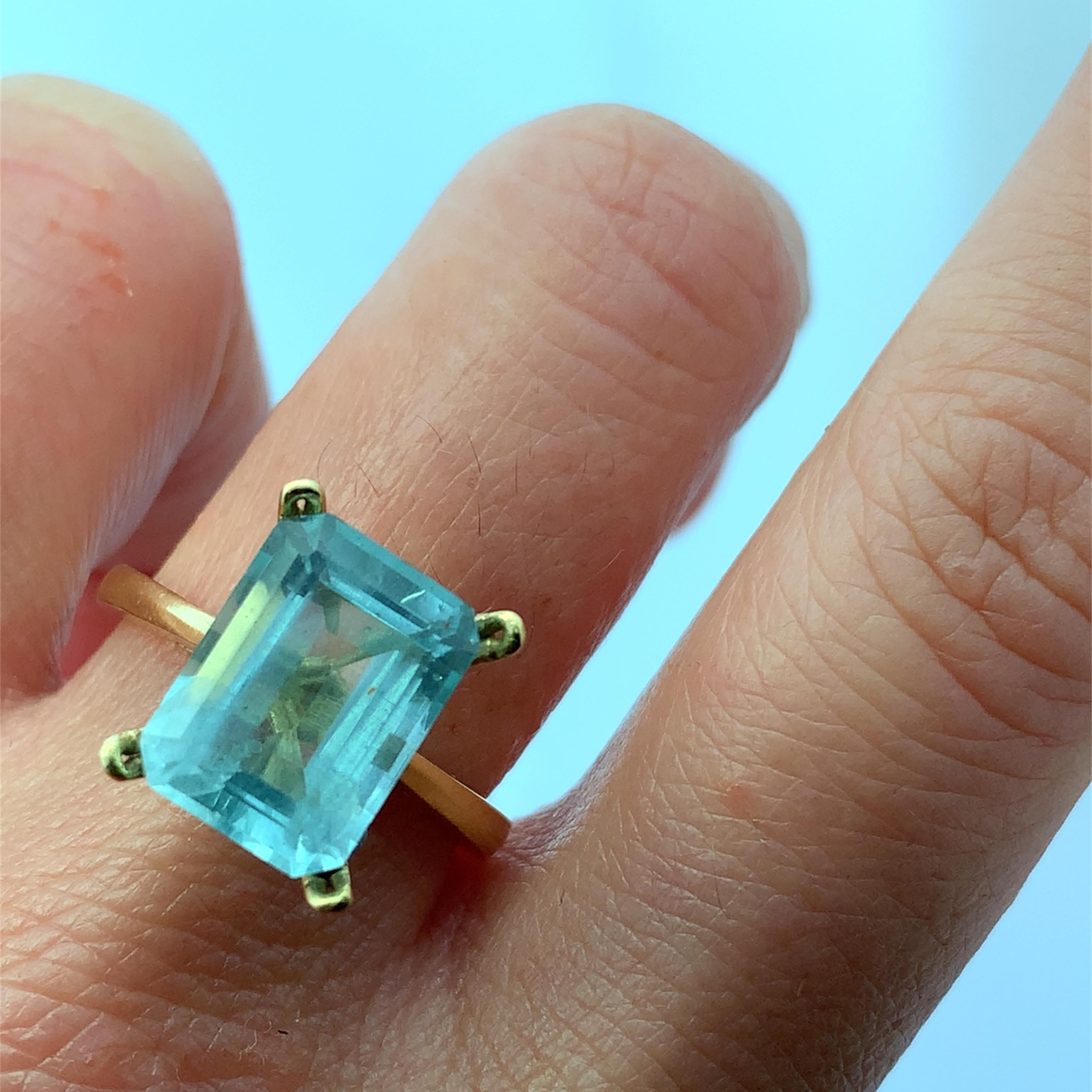 Discover the beauty of this stunning elongated 4.50ct aquamarine ring, set in a delicate 18k yellow gold band. The rectangular cut of the aquamarine stone measuring approximately 12x9mm captures light beautifully, making it a perfect accessory for
