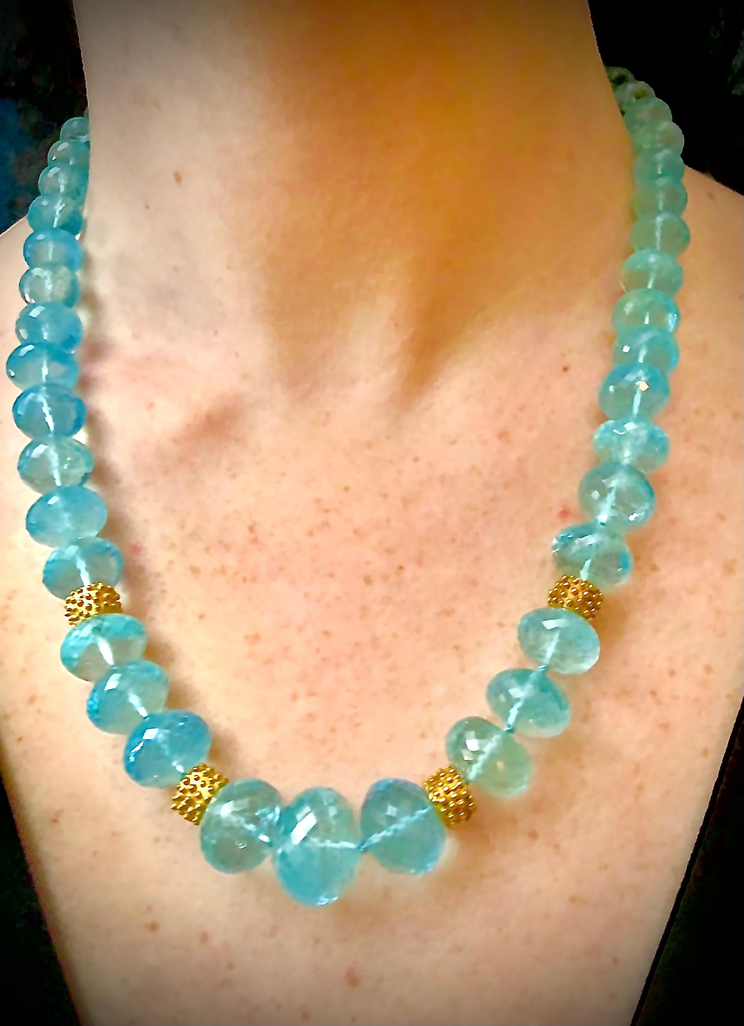 Impressive and luxurious long single strand necklace of large richly colored aquamarine sparkling faceted rondelles ranging in size from 18.12mm to 8.24mm. The piece is accented by four heavy 14kt yellow gold deeply textured large custom made