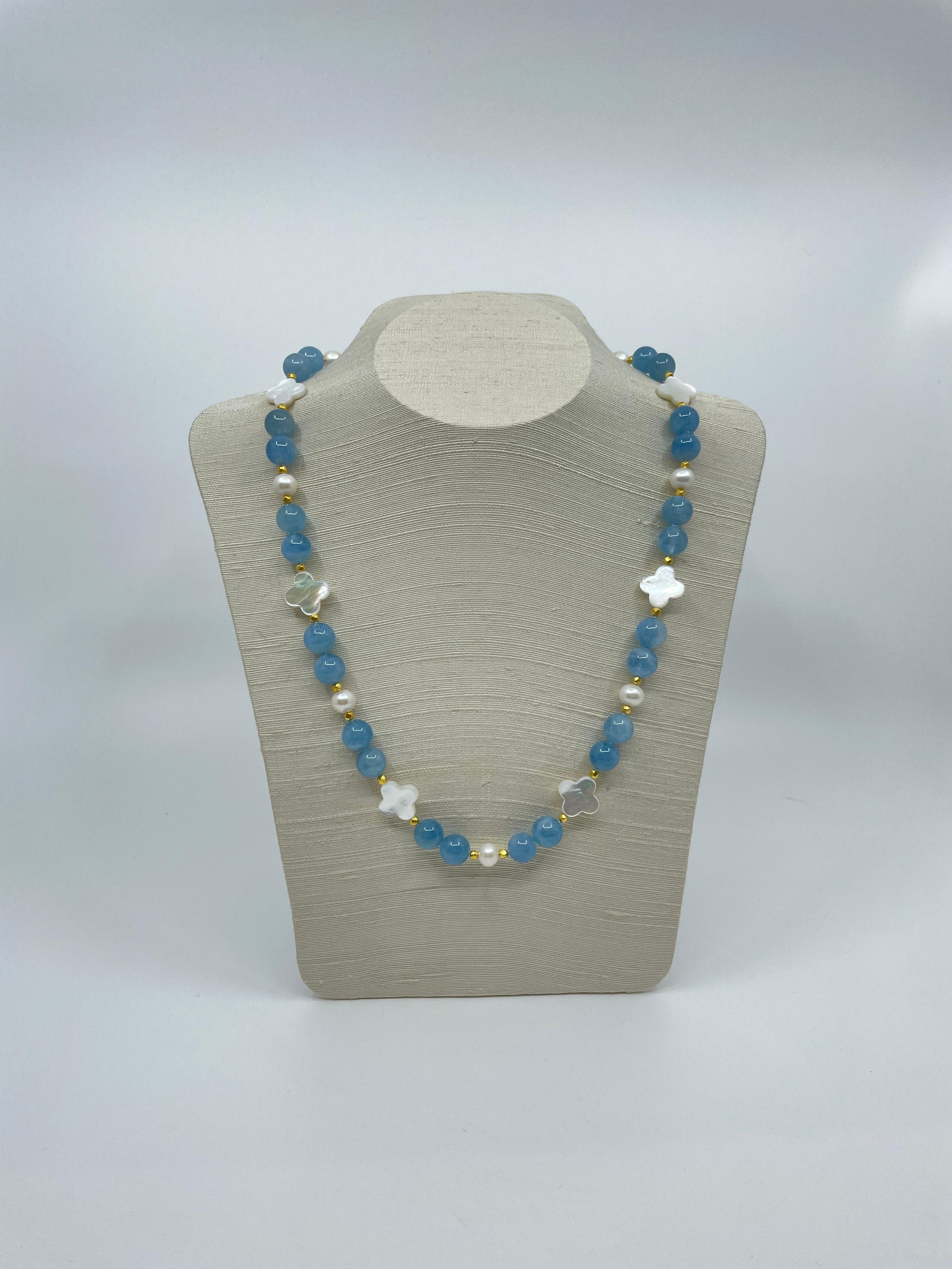 The strong blue color of the aquamarine beads is accentuated by the quatrefoil mother-of-pearl beads, freshwater pearls & 18k faceted gold beads. This attractive necklace at 23”(58.4cm) L is exquisite for summer days and nights.

Wearable Jewels by