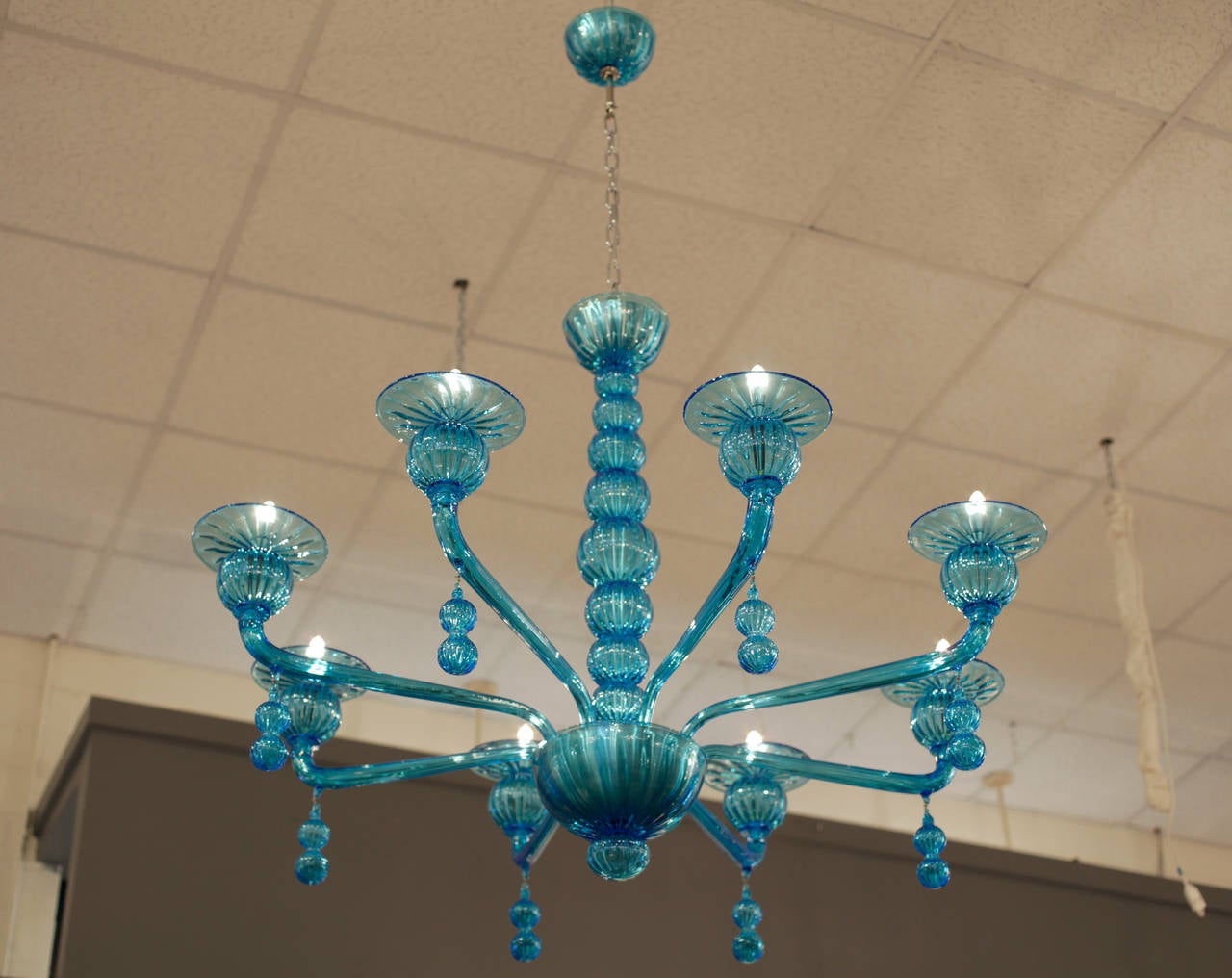 Hand blown Murano glass chandelier in aquamarine with eight branches and hanging pendants. Eight candelabra lights, rewired to US standards. Height including chain and matching glass canopy is 60 inches. Another flawless design by Barbini, circa