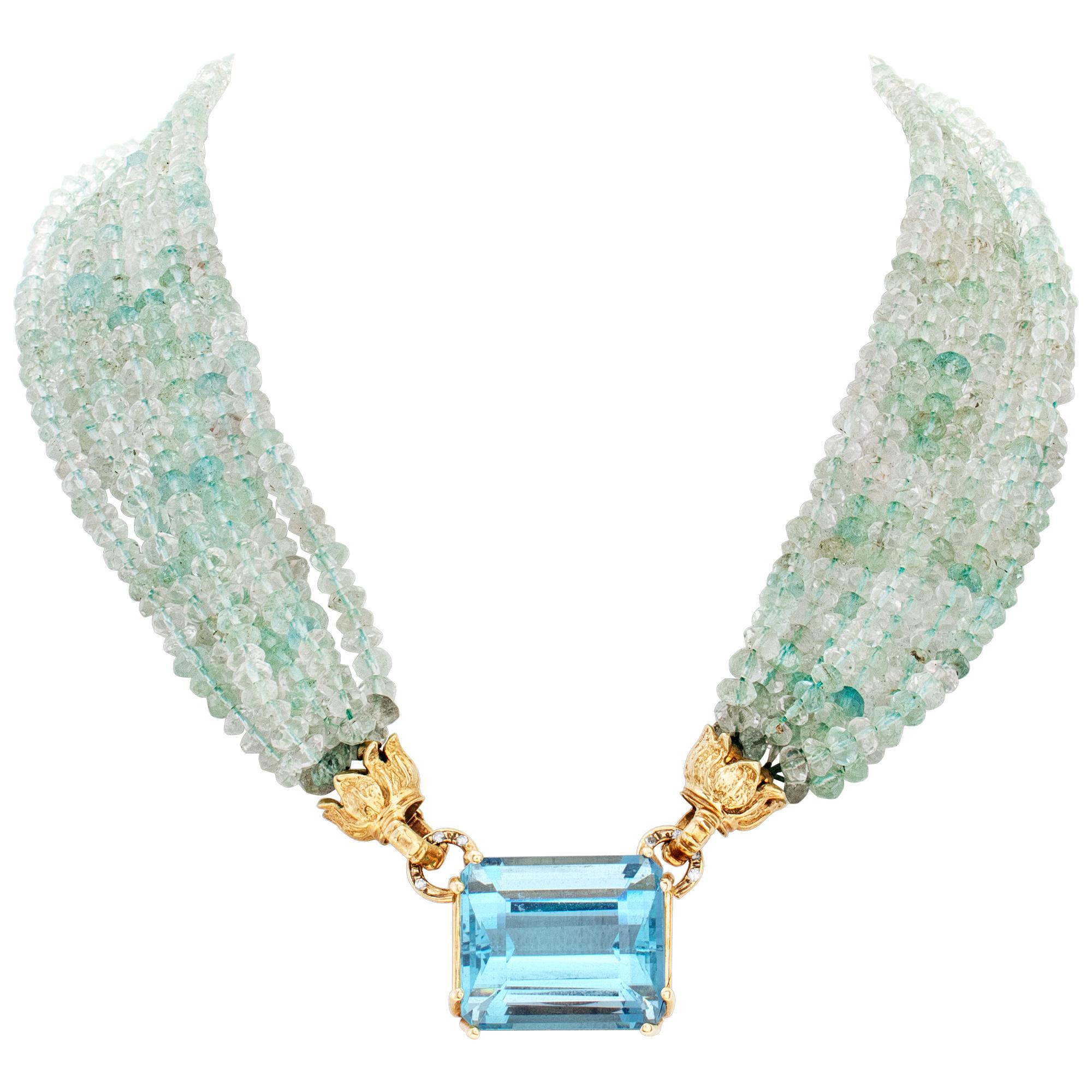 Over 12 carats center emerald cut natural gem-quality Aquamarine (from the Santa Maria mines in Brazil) set in 14K yellow gold, with 7 strands of 5 x 5.5 mm aquamarine beads necklace, set in 14K yellow gold. Center emerald cut gem quality Aquamarine