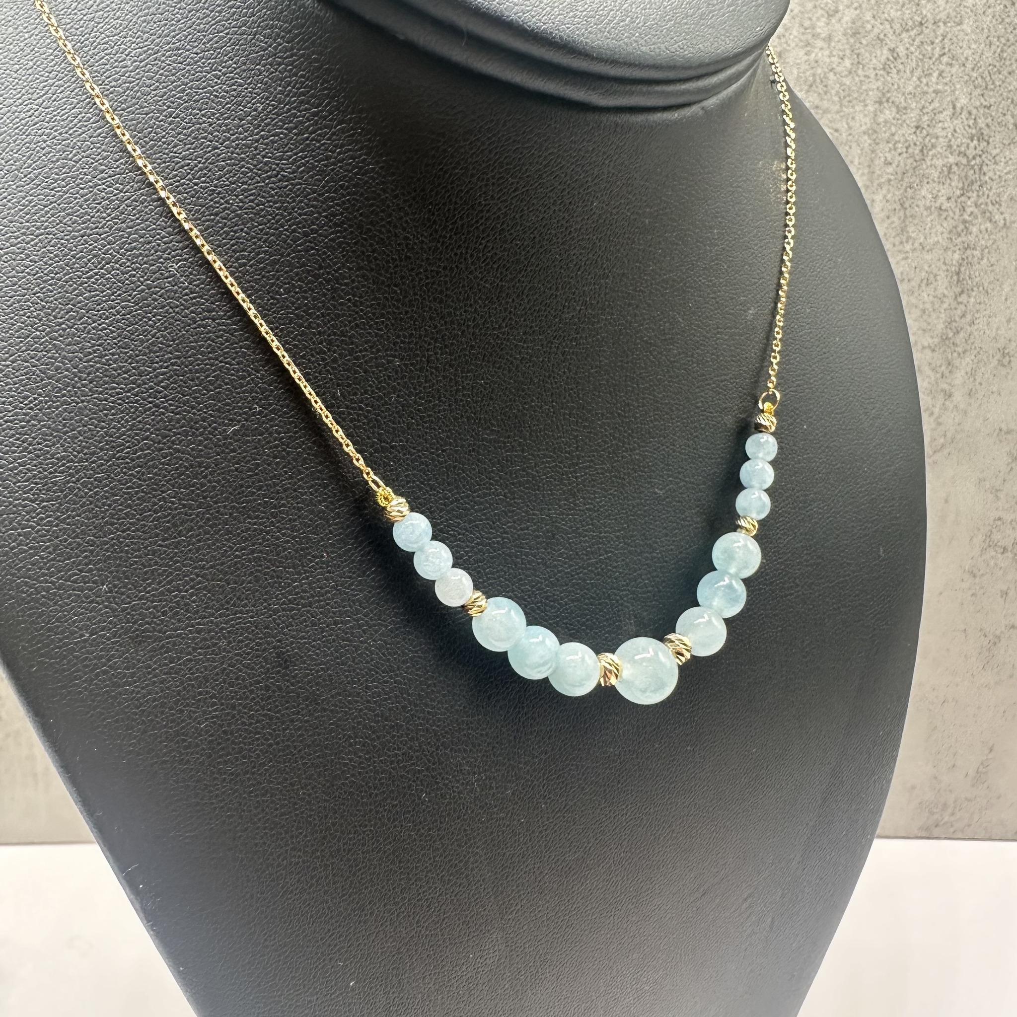 This beautiful Aquamarine Necklace in 14kt yellow gold features a stunning arrangement of round aquamarines, including (6) 4.3mm, (6) 6.2mm, and (1) 8.2mm stones, offering a radiant blue hue. With a 5.1-gram weight and an 18-inch length, this