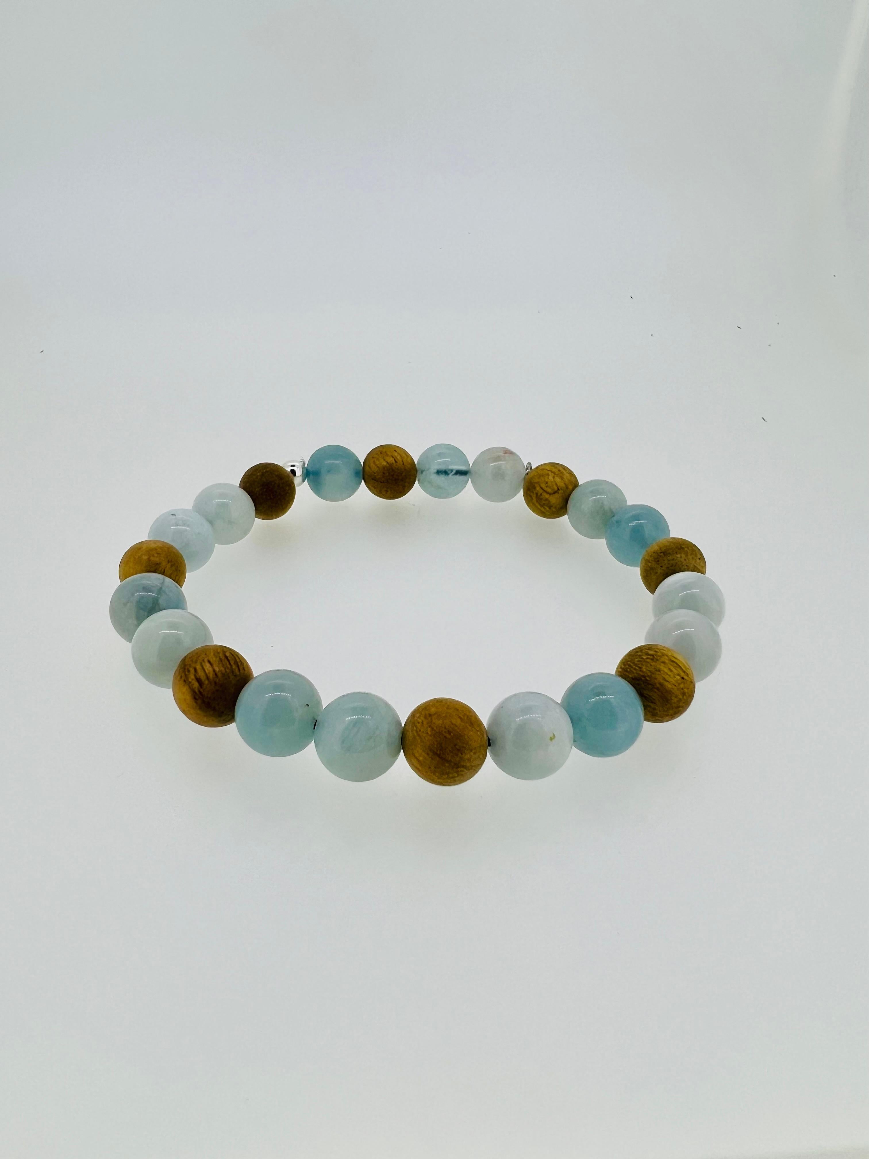 Introducing a distinctive men’s bracelet that blends the serene energy of the ocean with the richness of nature. Crafted with 8mm aquamarine beads, known for their calming blue hue and connection to the sea, and 8mm light Malaysian oud wood beads,