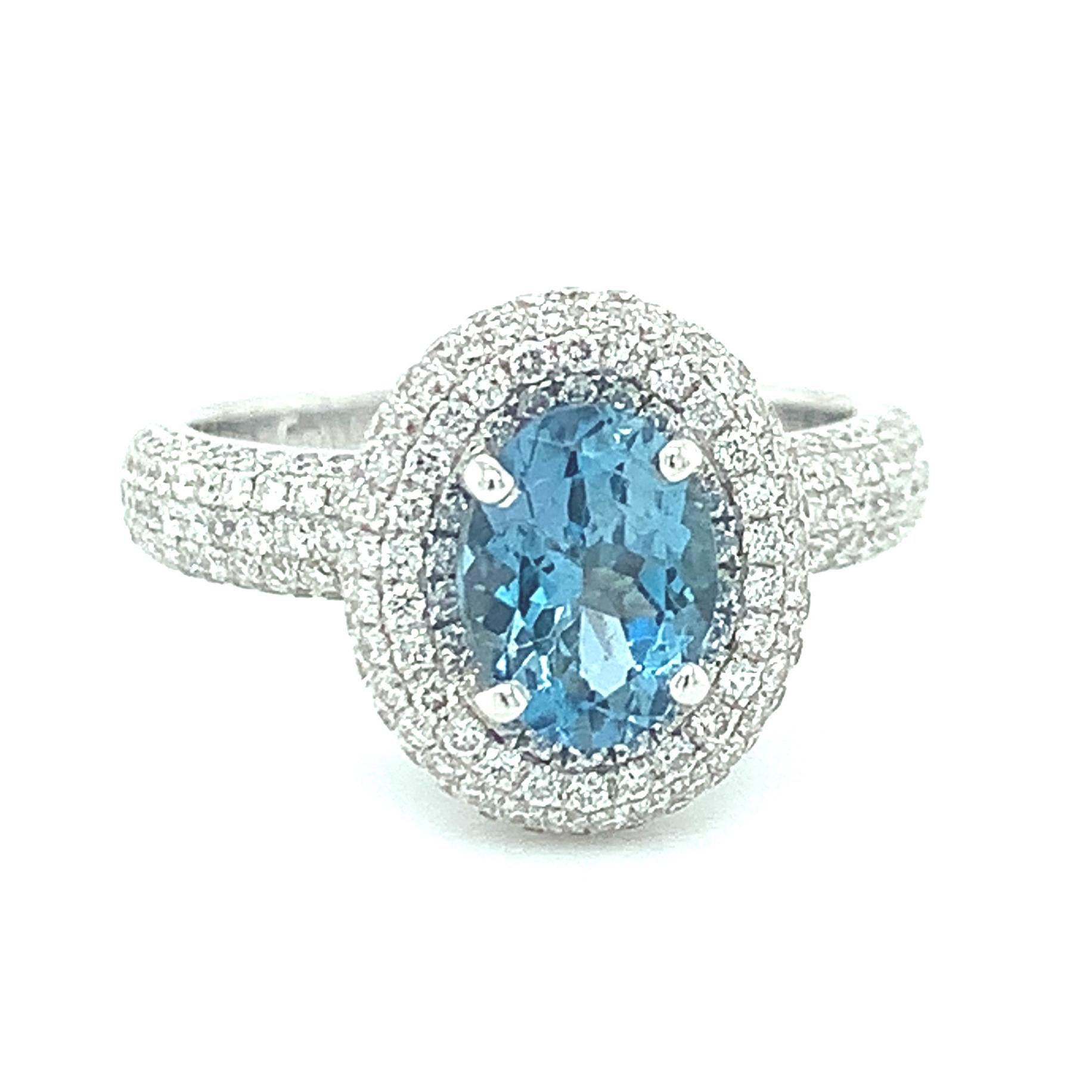 A beautifully deep blue aquamarine takes center stage in this stunning 18k white gold cocktail ring set with over a carat of brilliant white diamonds! The center aquamarine is a sparkling oval with extraordinary life and brilliance. It is surrounded