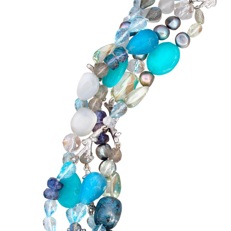 A fabulous statement piece featuring a mix of semi precious gems. 18 carat white gold coral clasp set with sapphires strung with a mix of kyanite, apatite, prasiolite, green beryl, blue topaz, aquamarine and pearl; interspersed with 18 carat white