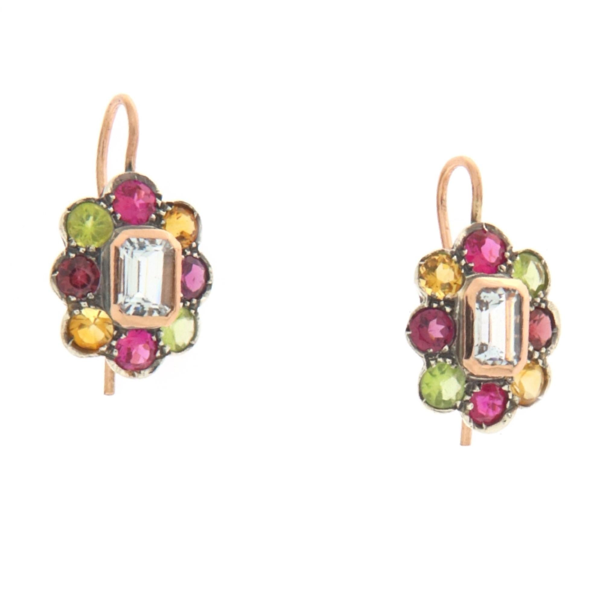 This pair of earrings, masterfully crafted in a refined combination of 14-karat yellow gold and sterling silver, is a true celebration of nature and its abundant color palette. At the heart of each earring sits an aquamarine, whose crystal-clear