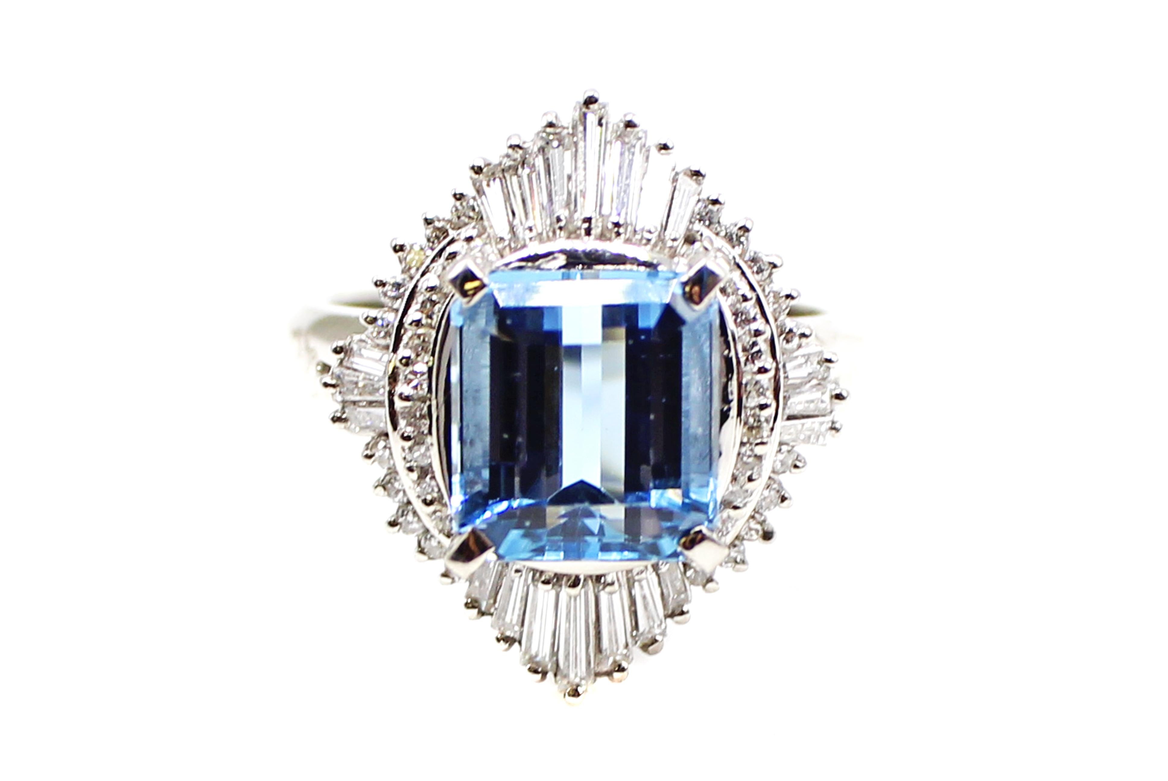 This bold ring shows off a perfectly rectangular Aquamarine weighing 3.91 carats. The lively pastel-blue center gem is set with 4 prongs and is embellished by 40 bright white and sparkly round diamonds and 20 tapered baguettes weighing a total of