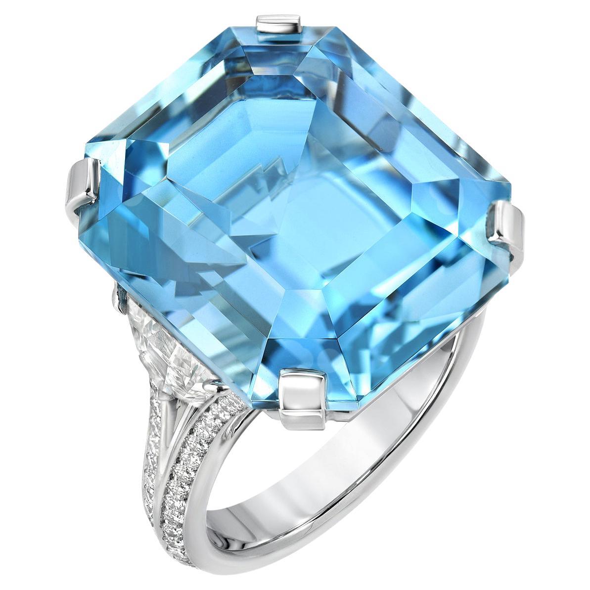 This incredible 20.37 carat natural Brazilian Aquamarine emerald-cut platinum ring, is flanked by a pair of F/VS2 Epaulet diamonds weighing a total of 0.96 carats, and surrounded by a total of 0.41 carat round brilliant diamonds.
Size 6. Resizing is