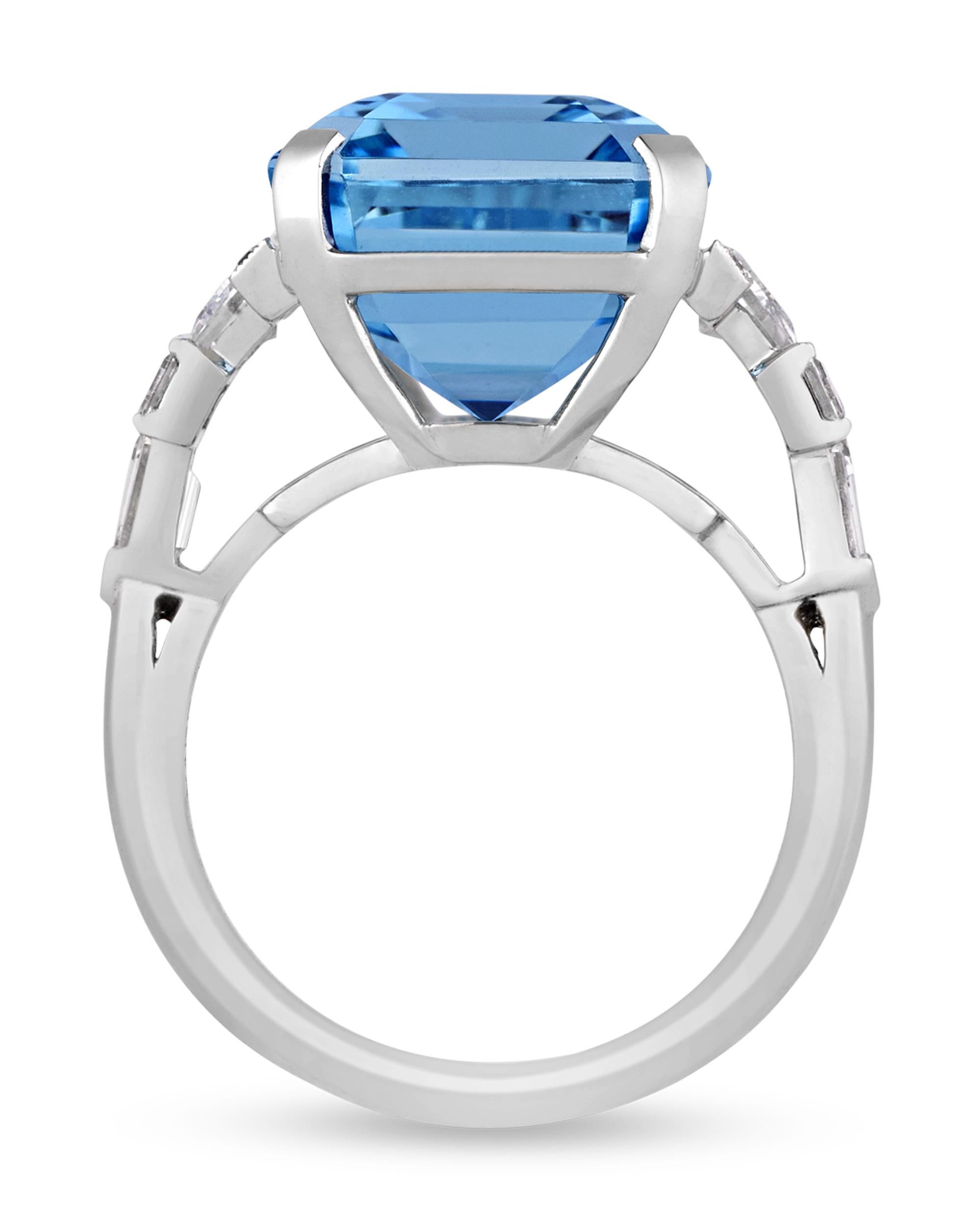 This exquisite ring by celebrated jeweler Raymond Yard features a breathtaking 13.35-carat emerald-cut aquamarine. The striking blue gemstone is accented by a combination of trapeze, bullet, square and round diamonds totaling 1.53 carats. The gems
