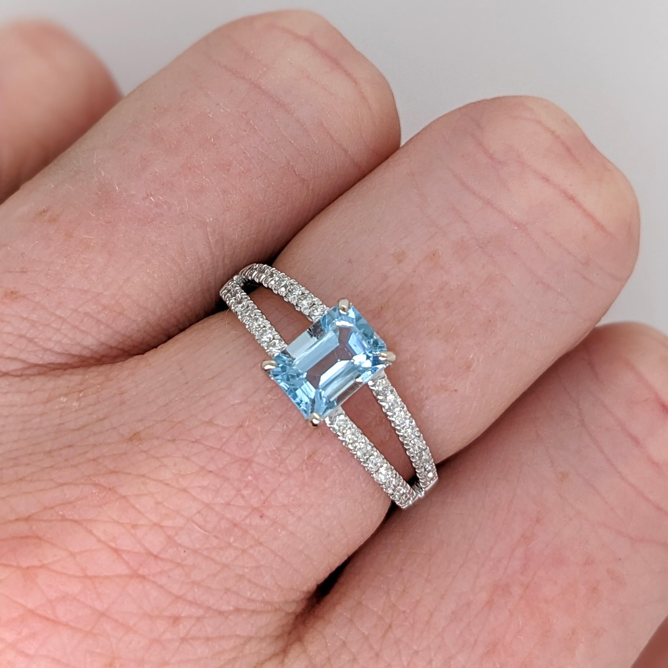 This beautiful ring features a 0.94ct emerald cut aquamarine with natural earth-mined diamonds set in solid 14k gold. The split shank design creates a visually captivating effect making it the perfect choice for both everyday wear and special
