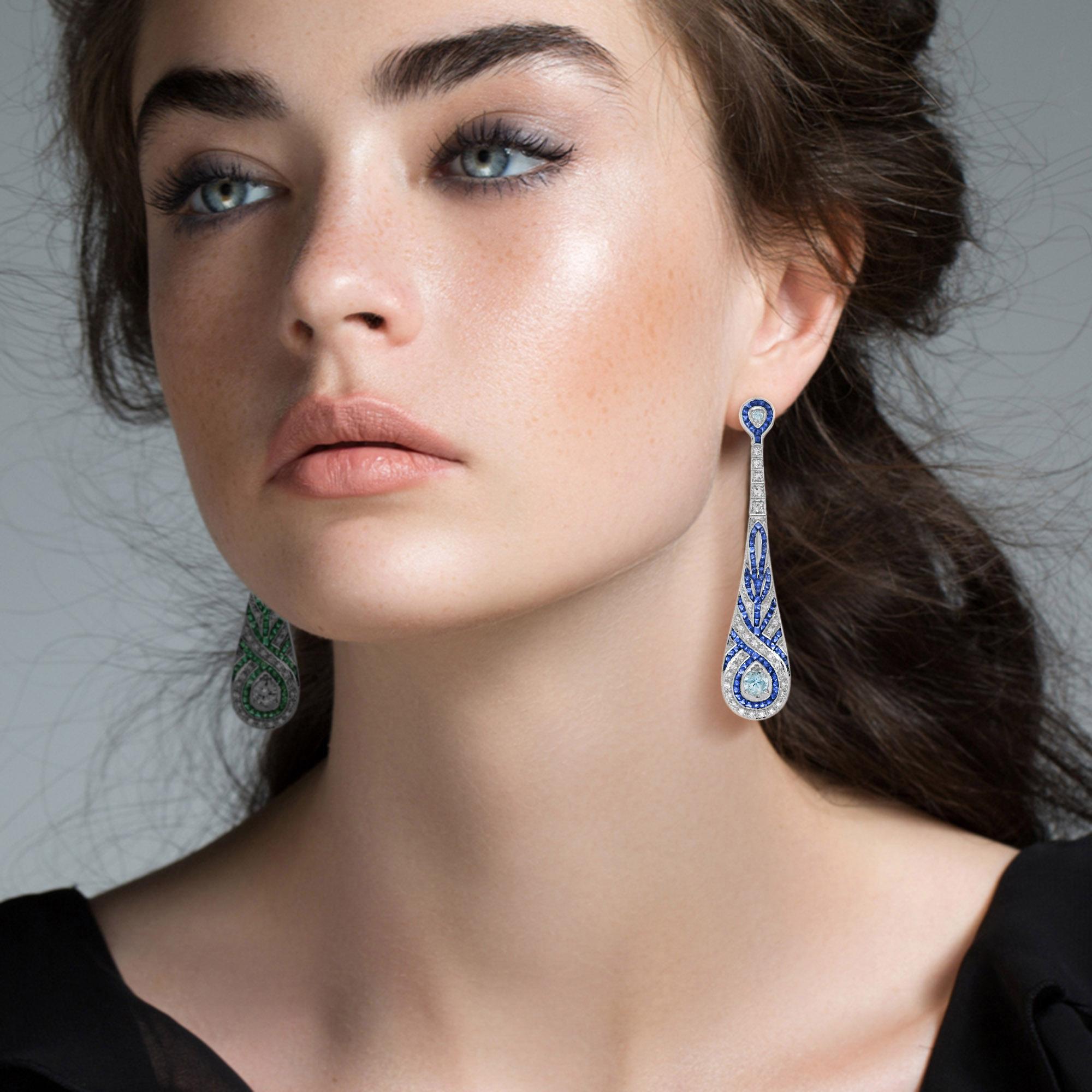 These fabulous Art Deco style ear drops, fabricated in 18k white gold, are stunning. Measuring 63 mm. long, a pair of bright and shining aquamarine – together weighting 0.90 carat, each ornamented with smaller diamonds bordered by French cut blue