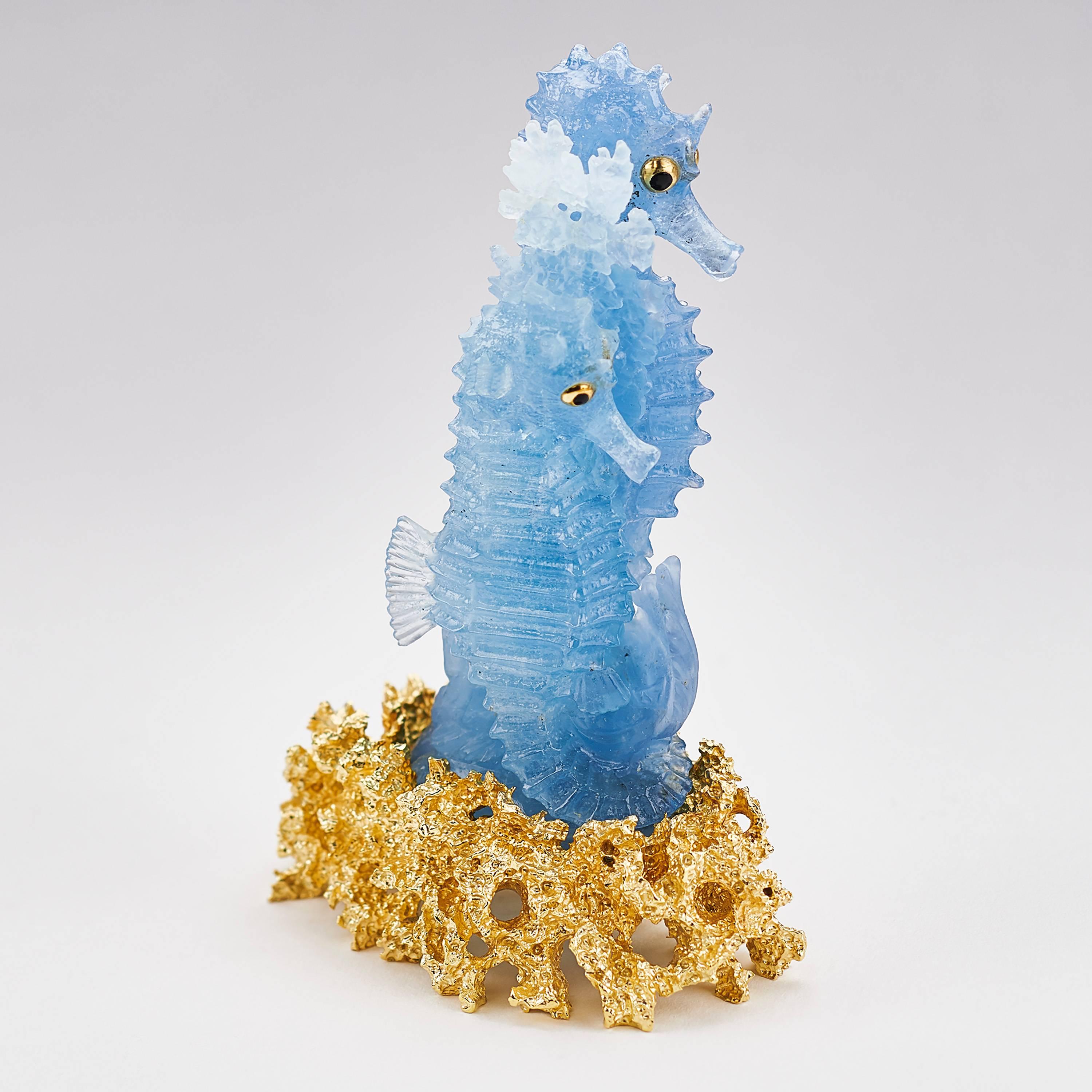 A lovely pair of seahorses designed by Henn.
The seahorses are carved out of one natural aquamarine crystal with 2 color shades by gemstone master carver Michael Peuster.
The eyes are blue sapphire cabs, set in 18ct yellow gold. The base is made out