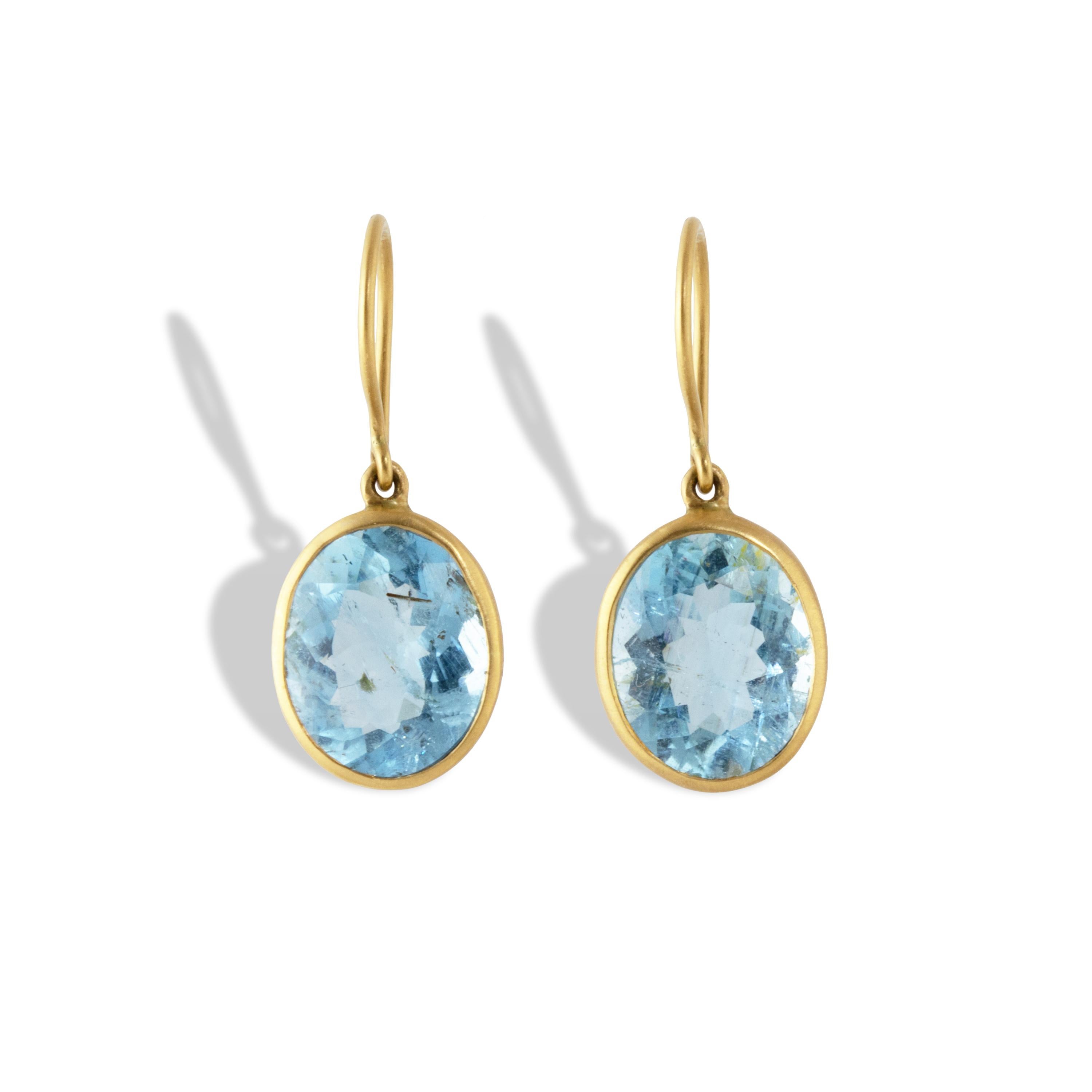 Elegant aquamarine earrings featuring spectacular bright blue aquamarine gemstones, approx. 11.52 carats total weight, set in a in a wavy 20k gold setting.  These earrings have a brushed finish and the setting was made entirely by hand. Santa Maria