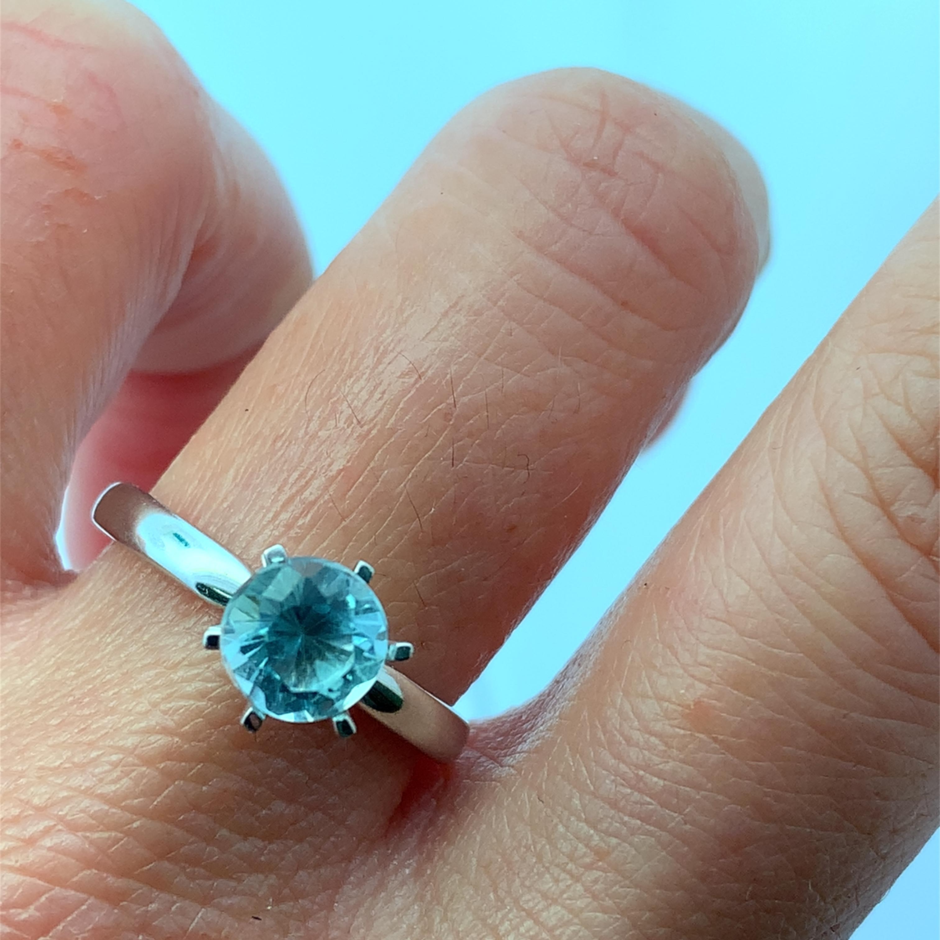 Découvrez la beauté de cette élégante bague en pierre précieuse aigue-marine bleue de 1,45ct, conçue pour captiver et charmer. La superbe pierre d'aigue-marine est sertie dans un élégant bracelet à 6 griffes en or blanc 18k, ce qui en fait un
