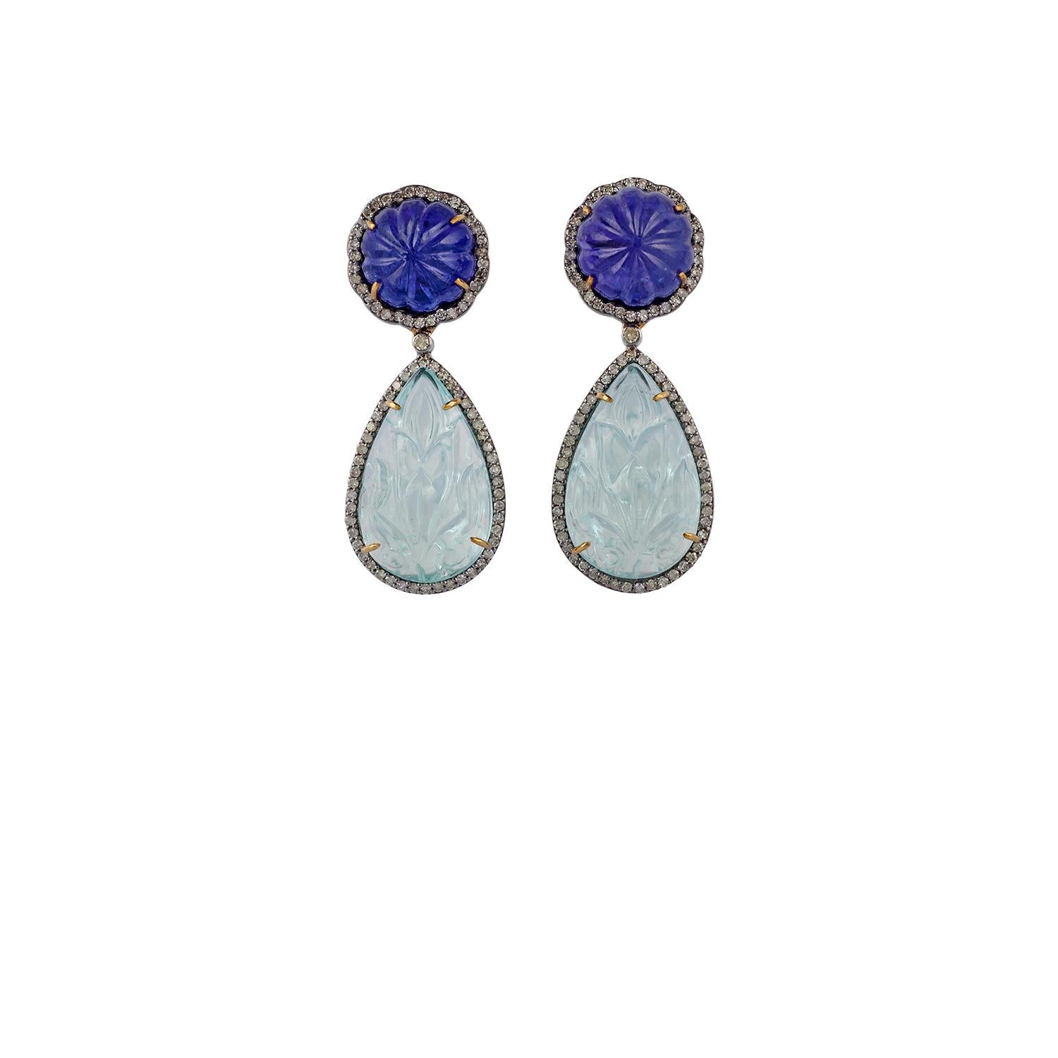 Cette élégante paire de boucles d'oreilles de style victorien présente 26,30 carats d'aigue-marine sculptée, 19,79 carats de tanzanite sculptée et 1,18 carats de diamants. Les boucles d'oreilles sont serties d'or et d'argent et pèsent 1,59 gramme