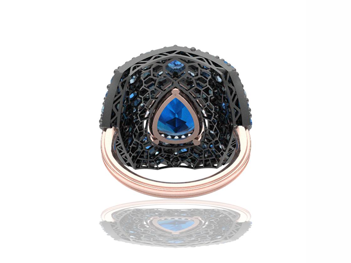 This modern bespoke ring is perfect for going out!  This ring is has a 4.5 carat pear shape Swiss blue topaz centered.  The center stone is surrounded by over four carats of blue from the cornflower blue of sapphire to the middle tones of topaz to