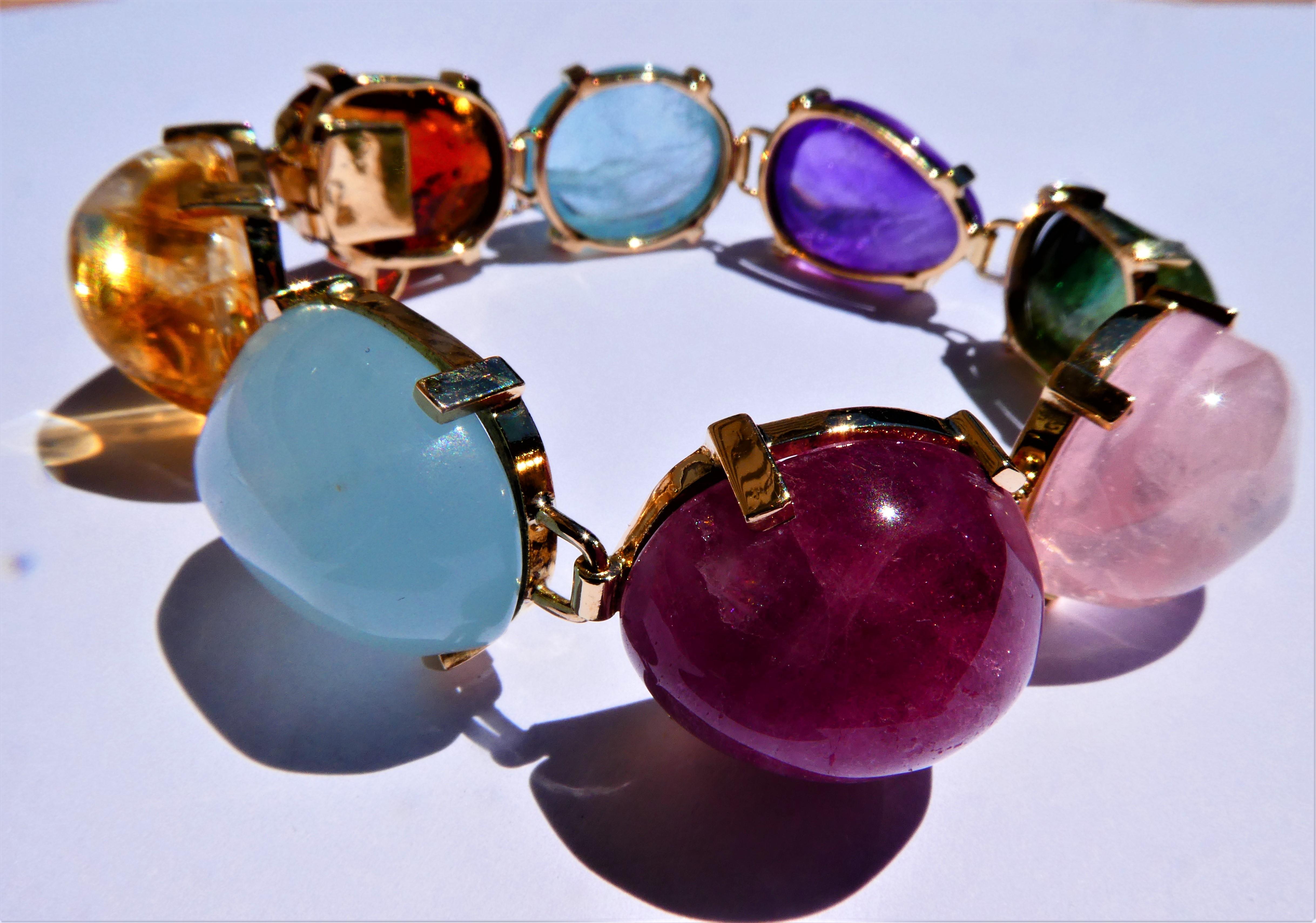 Gorgous multi-color Tutti-Frutti bracelet from the 1960s consisting of eight large semi-precious gemstones in an irregular oval cabochon cut. Two blue aquamarines, one purple amethyst, one pink rose quartz, one light and one dark yellow citrine, one