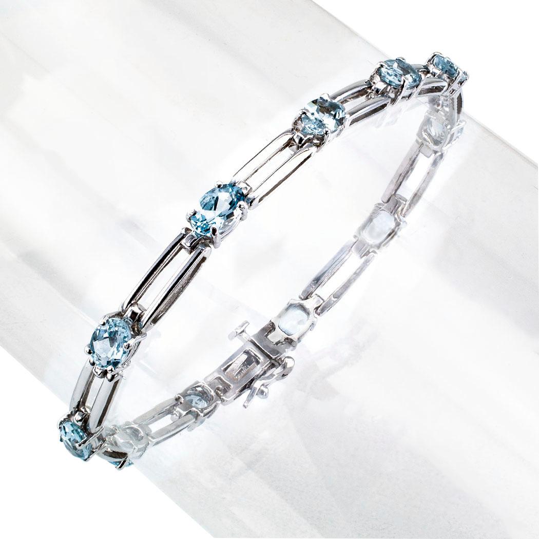 Aquamarine white gold link bracelet circa 1990. The design comprises a series of 11 oval aquamarines totaling approximately 3.50 carats, spaced at equal intervals defined by open, rectangular, connecting links, mounted in 14-karat white gold. We