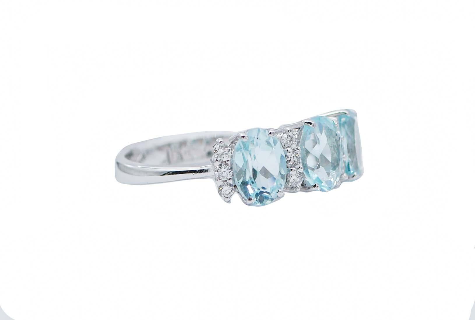 SHIPPING POLICY: 
Shipping costs will be totally covered by the seller.

Beautiful modern ring in 18 kt white gold structure mounted with three beautiful oval aquamarine colour topaz alternated with a row of three little diamonds.
Diamonds 0.27