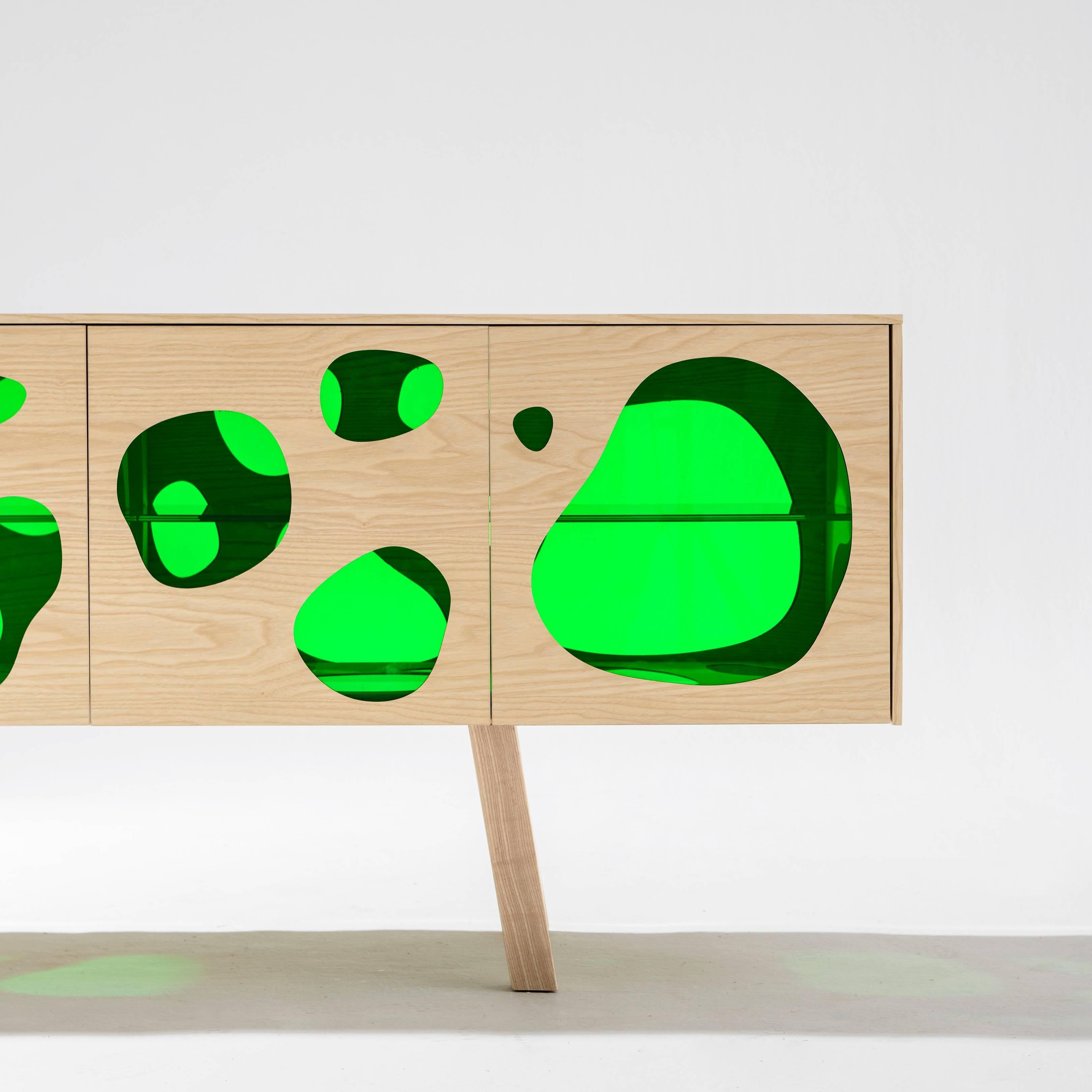 Sideboard designed by Fernando and Humberto Campana in 2016.
Manufactured in Spain.

The Campana brothers chose the coloured glass to give the impression of a fish tank. The cuboid Aquário buffet is built from either ash or pine wood, with