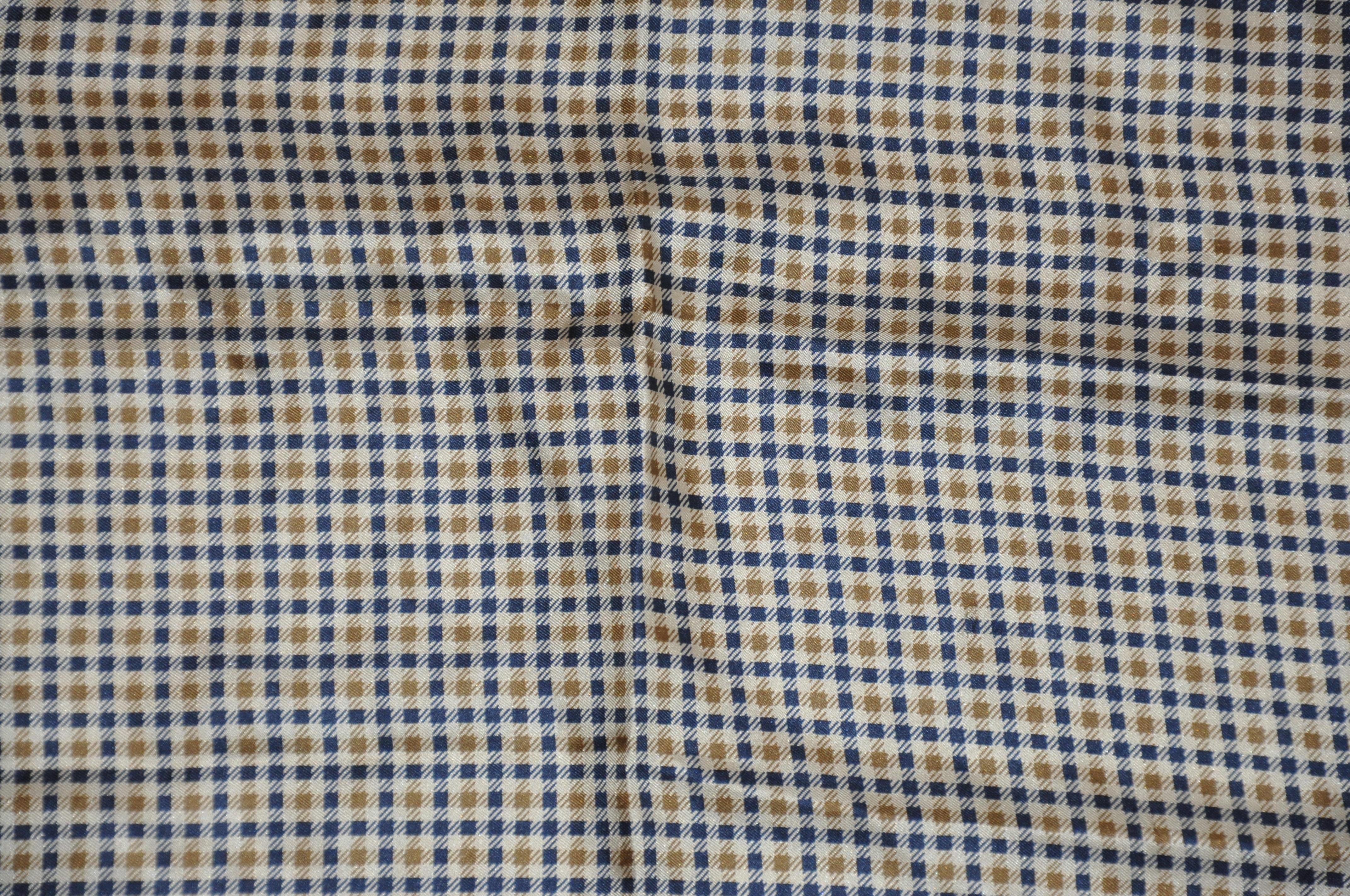        L'imprimé iconique Aquascutum dans un mouchoir en soie pour homme, accentué par des bords roulés à la main, mesure 15 pouces par 15 pouces. Fabriquées en Italie.