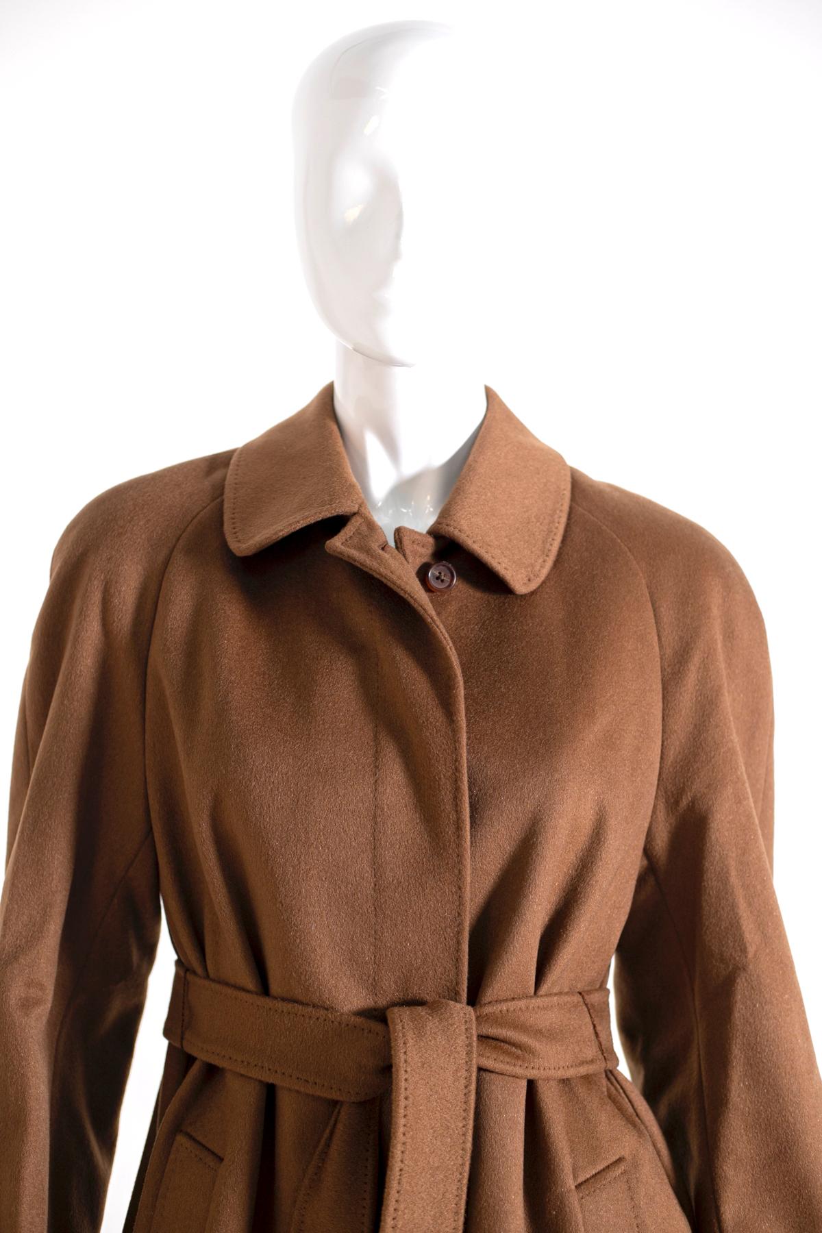 Manteau Aquascutum pour femme des années 90, couleur marron, en 100% pur cachemire. 
Ligne classique, avec cinq boutons sur le devant et deux poches confortables, longueur cheville avec ceinture assortie réglable. L'intérieur est doublé en 100%