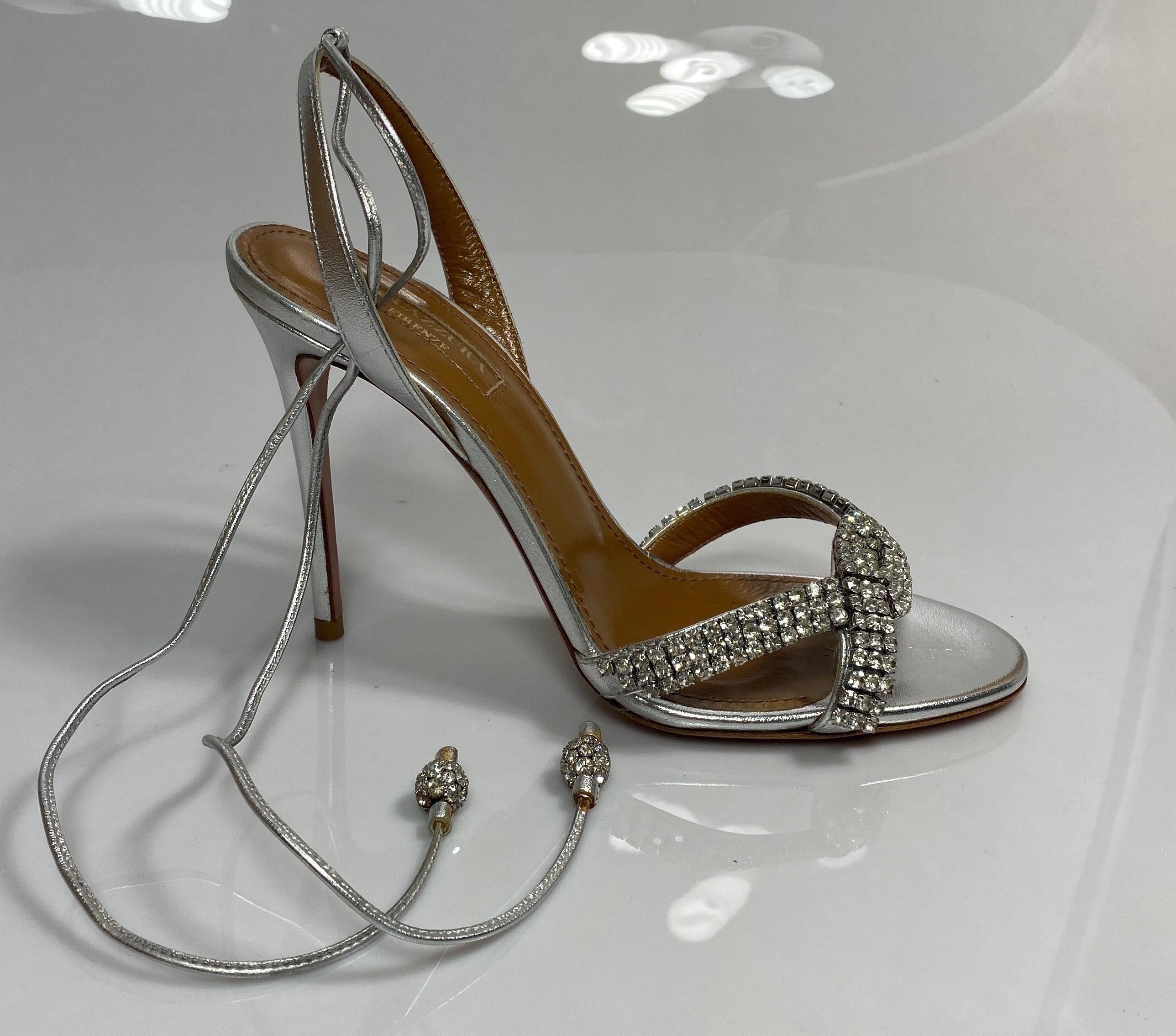 Aquazurra Silver “Dazzling Sandal” with crystals-Size 36
Description:
Rhinestone embellished sandal
Criss cross strap in front
Leather lace ankle tie with rhinestone balls on end
4.5” heel height
Excellent condition

