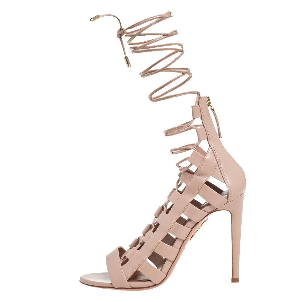 These sandals from Aquazzura look absolutely breathtaking! The sandals are crafted from beige leather and designed in a strappy layout with cutouts, rear zippers, and tie-ups. Balanced on 10.5 cm heels, this lovely pair will have everyone in