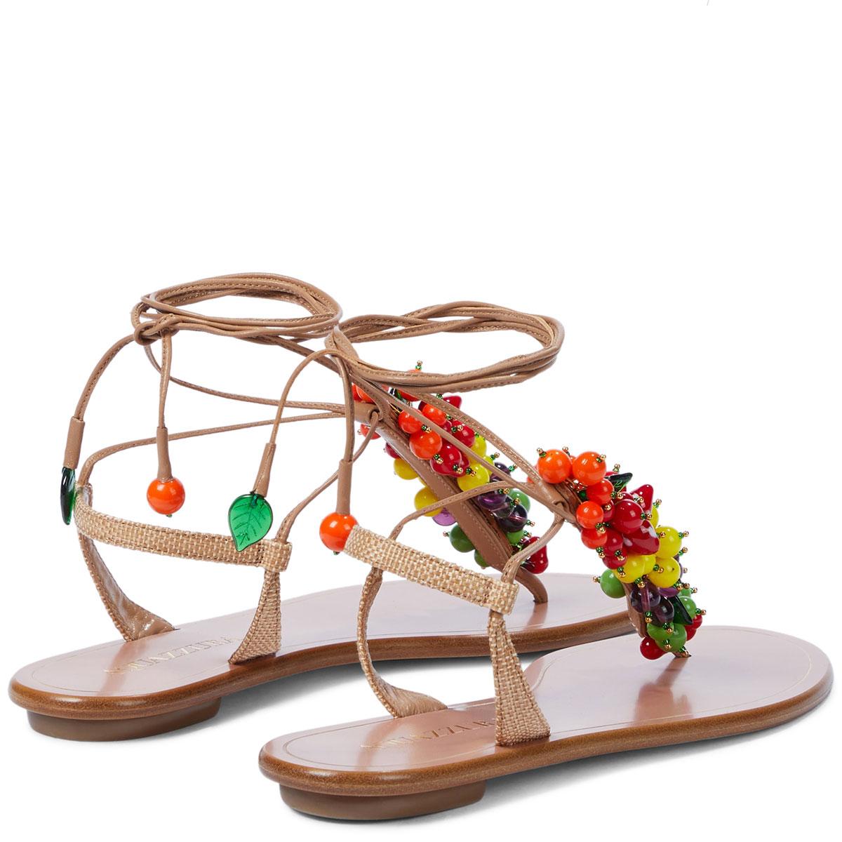 100% authentic Aquazzura Tutti Frutti thong sandals are trimmed in a tempting variety of tropical fruits in colorful Murano glass. Made from beige lamb leather and trimmed with raffia on the heel featuring wrap-tie fastenings at the ankles. Brand
