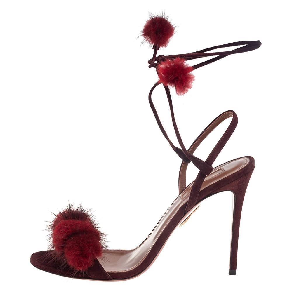 Pompom accents on the suede uppers, open toes, delicate ankle ties, and slim heels bring out the beauty of these Aquazzura sandals. Team them with chic casuals for maximum impact.

